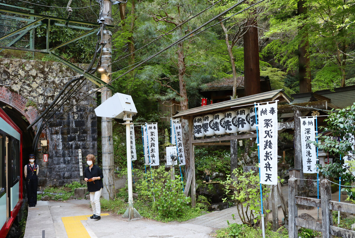 Die Hakone Tozan Bahn, Partnerbahn der RhB, im unteren Abschnitt: In der ersten Station des Aufstiegs wird tatsächlich und wortwörtlich Geld gewaschen. Weil hier das Wasser so klar hervorsprudelt, haben sich in den 1920er Jahren reiche Manager hier einen Badeort geschaffen und einen Schrein zu Ehren der Gottheit Benzaiten, wo das Waschen von Münzen deren Vermehrung bewirken soll. Wichtig sei aber, dass man die mehr gewordenen Münzen schnell ausgibt. Während der Zug hier in Tônosawa auf einen Gegenzug wartet, steht die Schaffnerin stramm am Zugsende und überwacht die Situation. 12.April 2022 