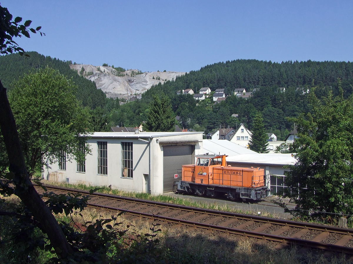 Die Lok 33 der Kreisbahn Siegen-Wittgenstein steht am 02.07.2008 vorm Lokschuppen in Herdorf am 02.07.2008.

Die Lok ist eine MaK G 763 C, sie wurde 1993 von der Maschinenbau Kiel GmbH (MaK) unter der Fabriknummer 700110 gebaut und an die damalige Siegener Kreisbahn GmbH geliefert. Kurz nach der Aufnahme, wurde sie 2008 an die K+S Kali GmbH verkauft, dort wird sie heute als Werkslok Nr. 2, im Werk Heringen eingesetzt. 

Die Lokomotive MaK G 763 C ist eine dieselhydraulische Lokomotive, die von der Maschinenbau Kiel (MaK) gebaut wurde. Sie wird dem 3. Typenprogramm von MaK, das ab 1977 angeboten wurde, zugerechnet. Sie stellt die Nachfolgerin der in 18 Exemplaren gebauten MaK G 761 C dar, unterscheidet sich von dieser durch einen strkeren MTU-Motor Reihe 396 und hat ein anderes Getriebe. Die Fhrerhuser waren aus Sicherheitsgrnden nicht mehr direkt vom Boden, sondern nur ber den Umlauf erreichbar. Die MaK G 763 C hat drei im Rahmen sitzende Achsen, die ber Gelenkwellen angetrieben werden. Sie hat eine Leistung von 560 kW und erreicht eine maximale Geschwindigkeit von bis zu 40 km/h. Sie bringt es auf eine Dienstmasse von bis zu 66 t. Ihr Tankinhalt betrgt 1.500 l.

Von der MaK G 763 C wurde zwischen 1982 und 1993 insgesamt 27 Exemplaren gebaut. Grte Abnehmer mit jeweils drei Lokomotiven waren die Siegener Kreisbahn und die Stdtischen Hfen Hannover. Alle Lokomotiven befinden sich noch im Dienst. Im Deutschen Fahrzeugeinstellungsregister wurde fr diese Bauart die Baureihennummer 98 80 0262 vergeben.

Technische Daten:
Spurweite:  1435 mm
Achsfolge:  C
Lnge ber Puffer:  9.870 mm
Achsstand: 3.800 mm
grte Breite:  3.100 mm
grte Hhe ber Schienenoberkante:  4.220 mm
Raddurchmesser neu:  1.000 mm
kleinster befahrbarer Gleisbogen: 40 m
Dienstgewicht:  54 - 66 t
Kraftstoffvorrat:  1500 l
    
Motor:  Sechszylinder-MTU-Dieselmotor, Typ  6V 396 TC13
Leistung: 560 kW
Drehzahl:  1.800 1/min
Getriebe: Voith, Typ  L3r4U2
Leistungsbertragung: hydraulisch
Hchstgeschwindigkeit:  32 - 40 km/h
