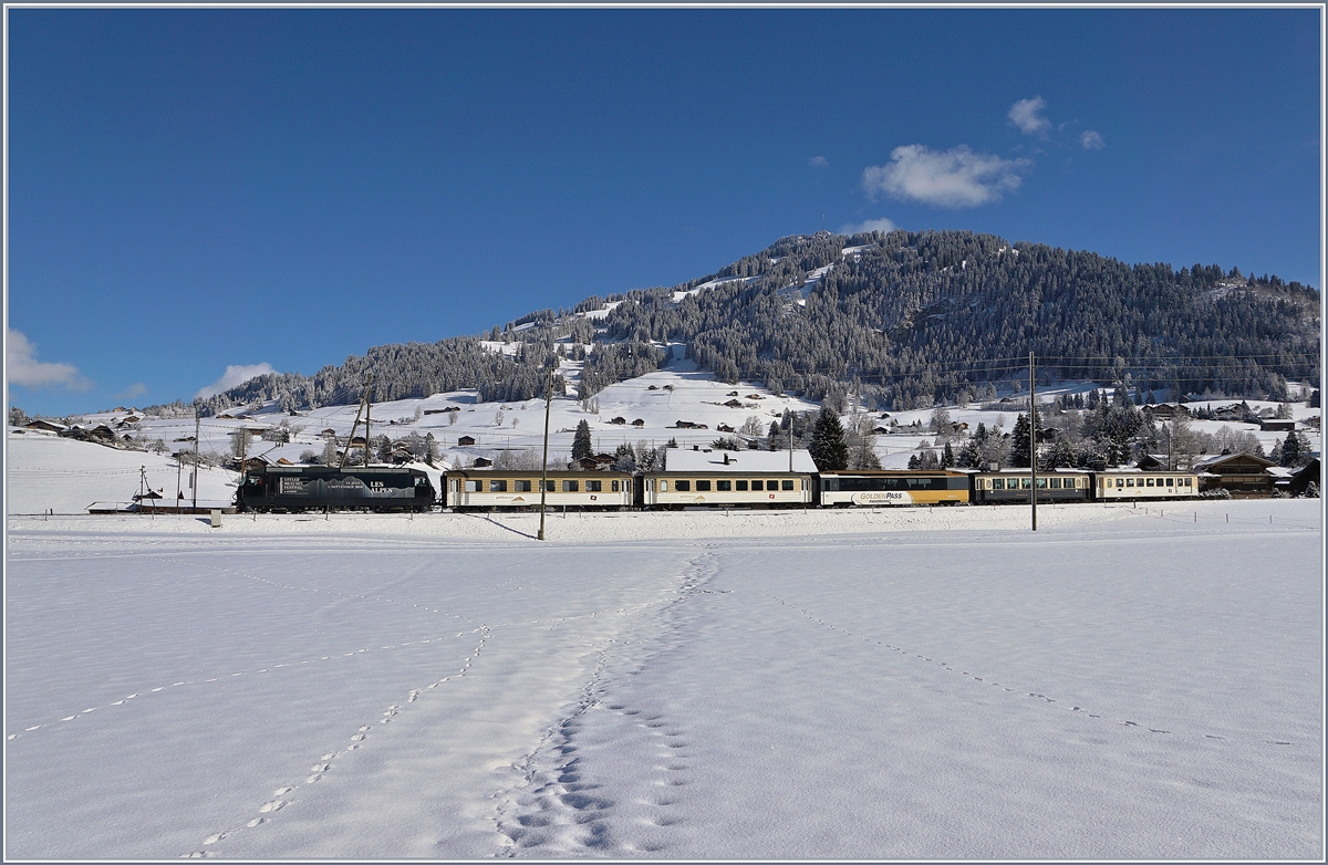 Die MOB Ge 4/4 8003 fährt mit ihrem  MOB-Belle  Epoque Zug bei Gstaad Richtung Montreux. Da die  Belle-Epoque Wagen zur Zeit in Chernex auf automatische Kupplung umgebaut werden, verkehr der Zug (wie im Fahrplan vorgesehen) mit  klassischem  Rollmaterial, wobei überraschenderweise doch noch ein  Belle-Epoque Wagen mitgeführt wird.
2. Feb. 2018