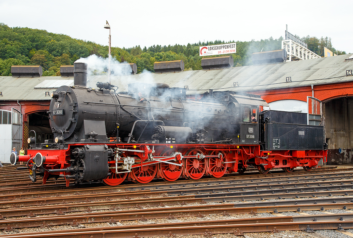
Die preuß. G10 Schlepptender-Güterzuglokomotive 57 3088 (ex G10 6011 Halle, ex DB 057 088-7) wird am 20.08.2016 beim Lokschuppenfest vom Südwestfälischen Eisenbahnmuseums in Siegen vor dem Ringlokschuppen präsentiert. Dass sie hier raucht verdankt sie der Tatsache, dass mit einer Nebelmaschine nachgeholfen wurde.

Die Lok wurde 1922 von Rheinmetall unter der Fabriknummer 550 gebaut und als G10 6011 Halle an die Deutsche Reichsbahn geliefert, 1925 erfolgte die um Bezeichnung in DR 57 3088 (nach dem Krieg DB 57 3088). Kurz vor der z-Stellung am 10.06.1968 wurde sie zum 01.01.1968 noch in DB 057 088-7 umgezeichnet. Am 24.06.1970 schied sie aus dem Bestand der DB aus. Von 1974 bis 2002 war sie als Denkmal auf dem Gelände des Bahnbetriebswerks Haltingen aufgestellt (mit Unterbrechungen als Ausstellungstück). Nachdem der Personalbestand in Haltingen zur Pflege gemäß den Auflagen des VM Nürnberg nicht mehr ausreichte, kam sie 2002 nach Siegen.

Die Preußische G 10 war eine Güterzug-Schlepptenderlok, die auf Basis des Fahrgestells der Preußischen T 16 und des Kessels der Preußischen P 8 entwickelt wurde.
Bei der Entwicklung der G 10 wurde das Fahrwerk der T 16 mit der seitenverschiebbaren ersten und fünften Achse deutlich modifiziert - die T 16 wurde danach mit diesem modifizierten Fahrwerk als T 16.1 weiter-gebaut. Die G 10 war für den schweren Güterzugdienst auf Hauptstrecken vorgesehen, durch ihre niedrigere Achslast konnte sie aber flexibler als die in etwa leistungsgleiche Preußische G 8.1 eingesetzt werden. Die G 10 wurde vereinzelt sogar auch im Personenzugdienst verwendet.

