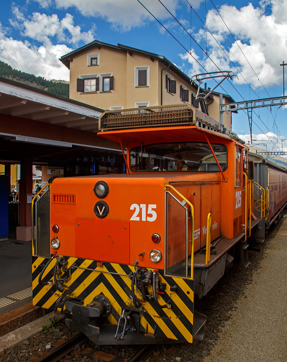 Die RhB Ge 3/3 - 215 steht am 06.09.2021 mit einem Güterzug im Bahnhof Samedan (1.705 m.ü.M.), aufgenommen aus einem Zug heraus.

Die Ge 3/3 ist eine dreiachsige elektrische Rangierlokomotive der Rhätischen Bahn (RhB). Bei der RhB zeigte sich Anfang der 1980er Jahre ein Engpass an Rangierlokomotiven, da die umgebauten und knapp 70-jährigen Ge 2/4 bedingt durch ihr Alter immer störanfälliger wurden. Ebenfalls reichte ihre Leistung nicht mehr aus, um wirtschaftlich arbeiten zu können. Die RhB entschied sich daher, gleichzeitig mit der Bestellung der zweiten Serie der Ge 4/4 II zwei moderne und leistungsfähige Rangierlokomotiven anzuschaffen.

Da man bei der ersten Serie der Ge 4/4 II gute Erfahrungen gemacht hatte, entschied man sich, die beiden Rangierlokomotiven ebenfalls in Thyristortechnik zu bauen. Die Thyristoren bilden zusammen mit Dioden einen stufenlos steuerbaren Gleichrichter, welcher den Gleichstrom-Reihenschlussmotor mit welligem Gleichstrom versorgt.

Der mechanische Teil wurde von Robert Aebi (RACO) gebaut. Der elektrische Teil stammt gleich wie bei der Ge 4/4 II von BBC. Einige Komponenten der Fahrzeuge – beispielsweise Fahrmotor, Kompressor und Vakuumpumpe – stimmen mit den entsprechenden Bauteilen der zweiten Serie Ge 4/4 II überein. Die beiden Maschinen mit den Betriebsnummern 214 (RACO Fabriknummer 1889) und 215 (RACO Fabriknummer 1899) wurden 1984 in Betrieb genommen.

TECHNISCHE DATEN:
Hersteller: RACO/ BBC
Spurweite: 1.000 mm
Achsformel: C
Länge über Puffer: 8.640 mm
Breite: 2.700 mm
Dienstgewicht: 33 t
Höchstgeschwindigkeit: 40 km/h (65 km/h Schleppfahrt)
Stundenleistung: 425 kW
Anfahrzugkraft: 102 kN
Stundenzugkraft: 60 kN bei 27 km/h
Treibraddurchmesser: 920 mm
Motorbauart: Reihenschlussmaschine
Stromsystem: 11 kV 16,7 Hz