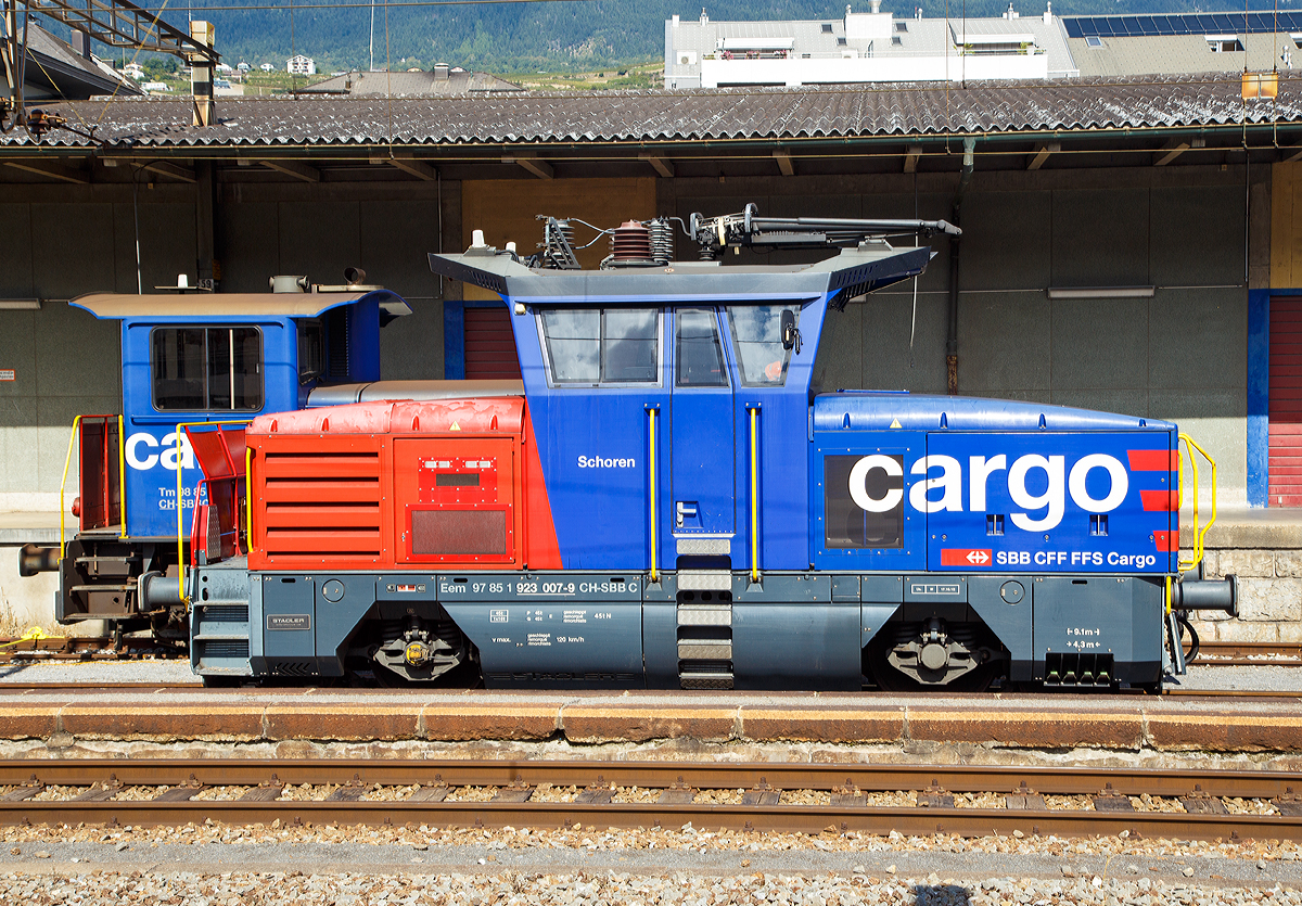 
Die SBB Cargo Eem 923 007-9  Schoren  (Eem 97 85 1 923 007-9 CH-SBB C) abgestellt am 16.09.2017 im Bahnhof Sion (Sitten).

Die Zweifrequenz-Hybridlokomotive vom Typ BUTLER wurde 2012 von Stadler Winterthur unter der Fabriknummer L-11000/007 gebaut. 

SBB Cargo bestellte im Juni 2010 beim Schweizer Fahrzeugbauer Stadler Rail in Winterthur 30 neue Zweifrequenz-Hybridlokomotive Typ Eem 923 001-030 für Güter- und Rangierdienste. Diese Hybridlok ist eine richtige Kompaktlok die unter Fahrleitungsbetrieb 15kV 16,7 Hz sowie 25kV 50 Hz Wechselstrom fahren kann und für die  letzte Meile  dank eines Dieselmotors auch auf nicht elektrifizierten Gleisen ohne Leistungsverminderung ihre Arbeit verrichten kann. Mit einer Leistung von 1500 kW, einer Höchstgeschwindigkeit von 120 Km/h sowie Vielfachsteuerungsmöglichkeit für bis zu 4 Eem 923 ist diese Lok für SBB Cargo ein wahrer Alleskönner. 

Weitere Technische Merkmale sind:
Verschleiß lose elektrische Bremse mit Rückführung der Bremsenergie ins Fahrleitungsnetz (Rekuperation) oder über Bremswiderstände im Dieselbetrieb.
Pneumatische indirekte Bremse für Zug und direkte Bremse für die Lok.
Ein leistungsstarker Schraubenkompressor mit einer Förderleistung
von 2400 Liter/min.

Technische Daten zur Eem 923
Hersteller: Stadlerrail Winterthur
Eigentümer: SBB Cargo
Anzahl der Fahrzeuge:  30
Spurweite:  1.435 mm
Achsformel:  Bo
Länge über Puffer:  9.100 mm
Achsabstand:  4.300 mm
Fahrzeugbreite:  3.100 mm
Fahrzeughöhe:  4.306 mm
Dienstgewicht (Tara)  45 t
Raddurchmesser Neu:  1.100 mm
Maximale Leistung am Rad:  1.500 kW (2040 PS)
Maximale Leistung Dieselmotor:  290 kW (394 PS)
Anfahrzugkraft:  150 kN
Höchstgeschwindigkeit:  120 km/h
Umgrenzungsprofil: UIC 505-I AB-EBV U3
Fahrdrahtspannung:  15kV 16,7 Hz und 25kV 50 Hz Wechselstrom
Zugsicherungsystem:  Signum-ZUB 262ct, ETM-S
Nachrüstungsmöglichkeiten:  ETCS-Level 2 / Indusi
Zugfunksystem:  GSM-R
Auslieferungsjahr:  2012-2013
