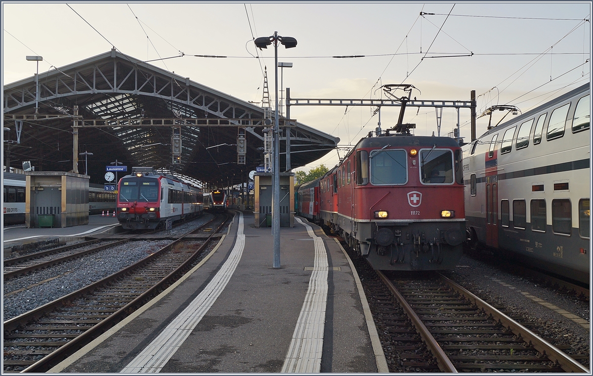 Die SBB Re 4/4 II 11172 und eine weitere Re 4/4 II warten mit dem EN Thello nach Paris in Lausanne auf die Weiterfahrt. Links im Bild verlässt ein Domino als S 12014 nach Vallorbe Lausanne.  
1. Juni 2018