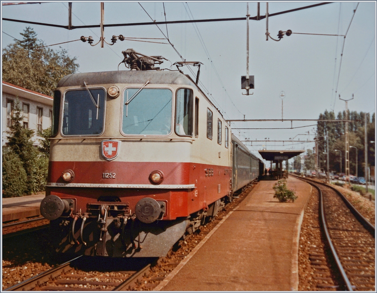 Die SBB Re 4/4 II 11252 mit dem Schellzug 526 Richtung Lausanne beim Halt in Grenchen Süd. 

8. Okt. 1984