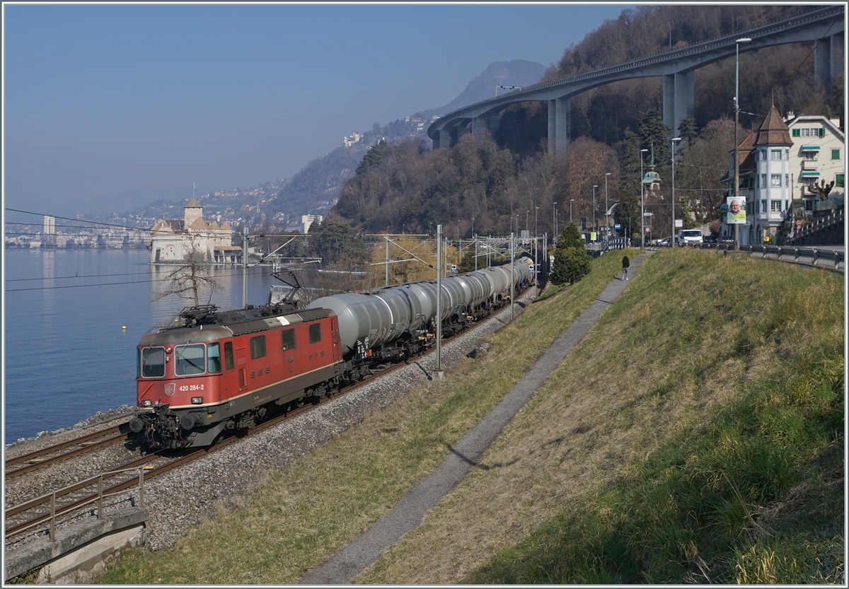 Die SBB Re 4/4 II 11284 (Re 420 284-5) ist mit einem Kesselwagenblockzug beim Château de Chillon auf dem Weg in Richtung Aigle. 

8. März 2022 