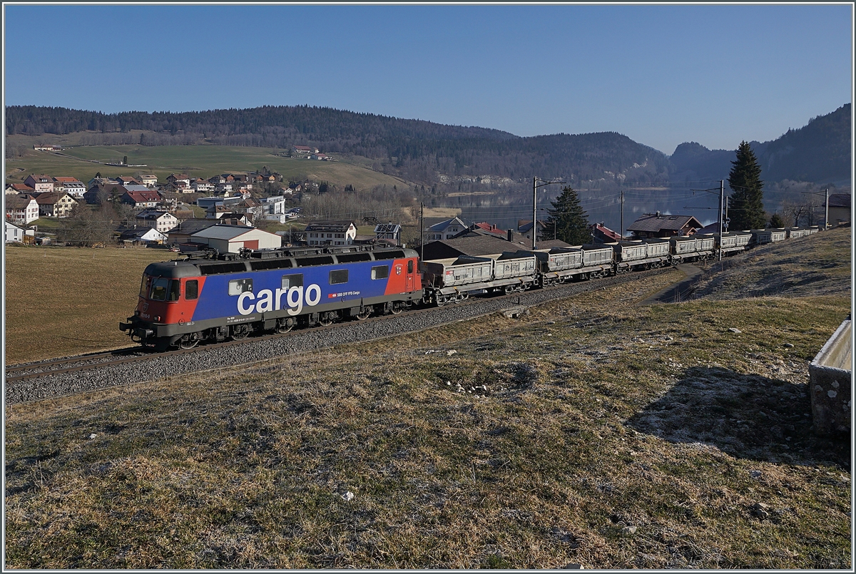 Die SBB Re 6/6 11610 (Re 620 010-9)  Spreitenbach  bringt etliche leere Fans-u Wagen als Güterzug 69701 von Lausanne-Triage nach Le Brassus und konnte hier bei Les Charbonnières mit dem Hintergrund des Lac de Brenet fotografiert werden. 

24. März 2022