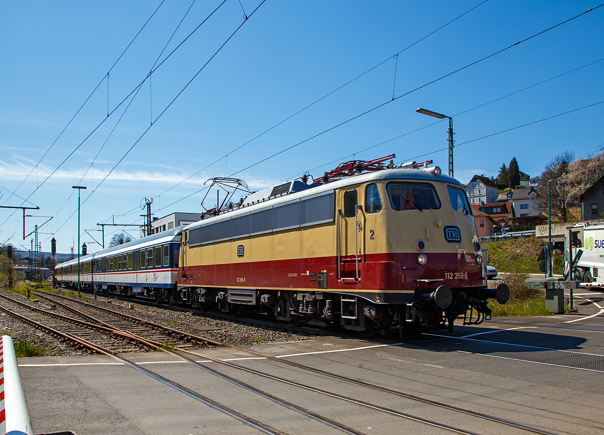 Die TRI 112 268-8, eigentlich heute 113 268-7 (91 80 6113 268-7 D-Train) der Train Rental International GmbH fhrt am 27.04.2021 mit einem n-Wagen-Zug durch Niederschelden in Richtung Siegen. 

Die Lok, eine sogenannte „Bgelfalten“ E10.12 mit Henschel-Schnellfahrdrehgestellen fr dem TEE Rheingold bzw. TEE Rheinpfeil, wurde 1962 von Krauss-Maffei in Mnchen-Allach unter der Fabriknummer 18927 gebaut, der elektrische Teil ist von den SSW - Siemens-Schuckert-Werke in Berlin. Als E 10 1268 wurde sie an die Deutschen Bundesbahn ausgeliefert. Mit der Einfhrung des EDV-gerechte Nummernsystems erfolgte zum 01.01.1968 die Umzeichnung in DB 112 268-8. Nach der deutschen Wiedervereinigung und dem darauffolgenden Vereinigung der beiden deutschen Staatsbahnen (DB und DR) wurde sie zum 01.01.1991 in DB 113 268-7 (91 80 6113 268-7 D-DB) umgezeichnet und fuhr so zuletzt bei der DB Fernverkehr AG bis zur Ausmusterung und Verkauf im Jahr 2015 an die TRI, wo sie wieder purpurrot/beige wurde.
