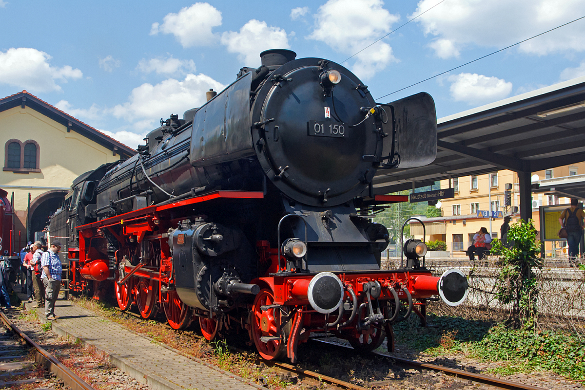 Die Zweizylinder-Heißdampf-Schnellzuglokomotive DB 01 150, ex DB 001 150-2, ist leider aufgrund eines Laufwerkschadens, beim Dampfspektakel 2014, nicht zum Einsatz gekommen. So stand sie warm abgestellt am 30.05.2014 im Eisenbahnmuseum Neustadt an der Weinstraße (Pfalzbahn - Museum).

01 150 wurde 1935 von Henschel in Kassel mit der Fabriknummer 22698 gebaut und an die DR geliefert. Sie zählt nicht zu den 50 Loks, die ab 1957 auf neue geschweißte Hochleistungskessel umgerüstet wurden, sondern noch den vollständig genietete Altbaukessel.

Bis zur Ausmusterung bei der DB 1973 war zuletzt in Hof beheimatet. 01 150 war bei den beiden großen Jubiläumsparaden (100 und 150 Jahre Deutsche Eisenbahn) dabei, 1935 als fabrikneue Lok und als Museumslok 1985, nach dem sie von der DB wieder aus Privathand zurück gekauft worden war. Sie befindet sich im Besitz der DB AG und wird vom DB Museum Nürnberg betreut. Sie wurde beim Großbrand des Depots in Nürnberg am 18.10.2005 schwer beschädigt.

Seit August 2012 gehört auch die 01 150 nach der Kesselneuzulassung durch das EBA wieder zum betriebsfähigen Museumslokbestand der DB AG. Sie ist vom DLW Meiningen bis September 2011 komplett aufgearbeitet worden und wurde zunächst der Öffentlichkeit als rollfähiges Exponat in Göppingen präsentiert. Eine optische Änderung erkannte man sofort, sie hatte auf Wunsch des Sponsors Märklin zu Marketingzwecken des nachgebildeten Modells große Windleitbleche (Bauart Wagner) und eine breite Frontschürze bekommen. 

Auf Grund erheblicher Verschleißerscheinungen wurde der nicht mehr aufarbeitungsfähige noch vollständig genietete Altbaukessel gegen einen in Meiningen gefertigten modernen geschweißten Nachbaukessel ersetzt, wodurch sich die Inbetriebnahme-Genehmigung des Eisenbahn-Bundesamtes bis August 2012 verzögerte. Seit September 2012 sind, sowohl die Wagner-Windleitbleche durch das DLW Meinigen gegen die kleineren Witte-Windleitbleche ausgetauscht, als auch die breite Frontschürze zurückgebaut worden, sodass sie nun dem letzten Betriebszustand der Bundesbahnära vor ihrer Ausmusterung entspricht. 

Am 23. Mai 2013 wurde sie bei einem Festakt im Beisein der Eigentümerin übergeben. Nach Angaben der Deutschen Bahn AG wird 01 150 zukünftig im SEH Heilbronn beheimatet und von der Eisenbahnstiftung Joachim Schmidt im Auftrag des Verkehrsmuseums Nürnberg betreut und betrieben. 

Die Aufarbeitung der zerstörten Lokomotive hat nach Auskunft der DB AG insgesamt rund 1.000.000 Euro gekostet, dabei wurden alleine durch Olaf Teubert in zwei Jahren 500.000 Euro an Spendengeldern zur Rettung der Lokomotive eingesammelt.

Sie hat die NVR-Nummer 90 80 0001 150-6 D-EJS.

TECHNISCHE DATEN der 01 150:
Bauart:  2’C1’ h2
Gattung:  S 36.20
Spurweite:  1.435 mm (Normalspur)
Länge über Puffer:  23.940 mm
Höhe:  4.550 mm
Dienstgewicht:  111,1 t (ohne Tender)
Leergewicht Lok und Tender: 169 t Dienstgewicht Lok und Tender: 199 t
Radsatzfahrmasse:  20,2 t
Höchstgeschwindigkeit:  vorwärts 130 km/h / 80 km/h 
Indizierte Leistung:  1.648 kW (ca. 2.240 PS)
Kuppelraddurchmesser:  2.000 mm
Treibraddurchmesser:  2.000 mm
Laufraddurchmesser vorn: 1.000 mm 
Laufraddurchmesser hinten:  1.250 mm
Steuerungsart:  Heusingersteuerung mit Hängeeisen
Zylinderdurchmesser:  600 mm 
Kolbenhub:  660 mm
Kesselüberdruck:  16 bar
Anzahl der Heizrohre:  107 
Anzahl der Rauchrohre:  70 
Heizrohrlänge:  6.800 mm
Rostfläche:  4,32 m²
Tender:  2' 2 T 34
Wasservorrat: 34,0 m³
Brennstoffvorrat:  10,0 t Steinkohle
