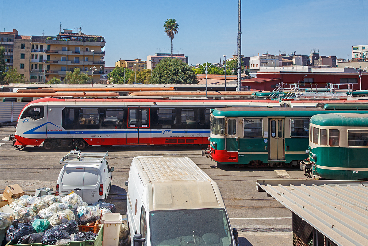 Ein Blick ins Depot der Ferrovia Circumetnea (FCE) in Catania Borgo am Sonntag den 17.07.2022, leider ruht sonntags der ganze Bahnbetrieb der 950 mm Schmalspurbahn.

Links der moderne Dieseltriebzug FCE DMU-003 vom Typ Newag „Vulcano“ (series DMU 001-004). Davor der Triebwagen FCE ADe 17 (Baujahr 1980), sowie davor der Beiwagen FCE R552.

Der Newag „Vulcano“ (Baureihe DMU 001-004) ist ein Dieseltriebwagen, der vom polnischen Hersteller NEWAG S.A. für die Ferrovia Circumetnea in Catania gebaut wurde. Seit Mai 2016 sind sie im Einsatz. 

Die Vulcano sind moderne, zweiteilige Fahrzeuge, die mit integrierten „Powerpack“-Antriebssystemen mit elektrischem Getriebe ausgestattet sind, die speziell für diese Fahrzeuge entwickelt wurden. Fortschrittliche technische Lösungen im Antriebssystem, Getriebesystem und Karosseriestützsystem ermöglichten es, Geräusche im Fahrgastraum zu dämpfen. Die Konfiguration des Innenraums des Fahrgastraums ermöglicht den Betrieb des Fahrzeugs sowohl im Stadt- als auch im Vorortverkehr. Die Anzahl der Sitzplätze beträgt 106 inkl. 7 Klappsitze und kann je nach Bedarf des Schienenverkehrsträgers variiert werden. Die Fahrzeuge sind vollklimatisiert.

Eine Einheit ist mit einer behindertengerechten Toilette (gemäß TSI PRM) in hermetisch dichter Bauweise ausgestattet und die interne Türzone ist mit automatischen Rollstuhlliften ausgestattet. Diese Dieseltriebzüge können mit einer Höchstgeschwindigkeit von bis zu 100 km/h fahren und sind für Mehrfachtraktion ausgelegt.

TECHNISCHE DATEN der Newag „Vulcano“:
Hersteller: Newag S.A.
Gebaute: 4
In Betrieb: Mai 2016
Spurweite: 950 mm
Achsfolge: Bo'Bo'+Bo'Bo'
Länge: 37.260 mm
Höhe: 3.530 mm
Breite: 2.526 mm
Drehzapfenabstand: 11.600 mm
Eigengewicht: 68,8 t
Leistung: 2 x 390 kW
Höchstgeschwindigkeit: 100 km/h
Türen ja Seite: 2 (je 1.300 mm breit)
Fußbodenhöhe über SOK: 550 mm
Sitzplätze: 106
Stehplätze: 66

