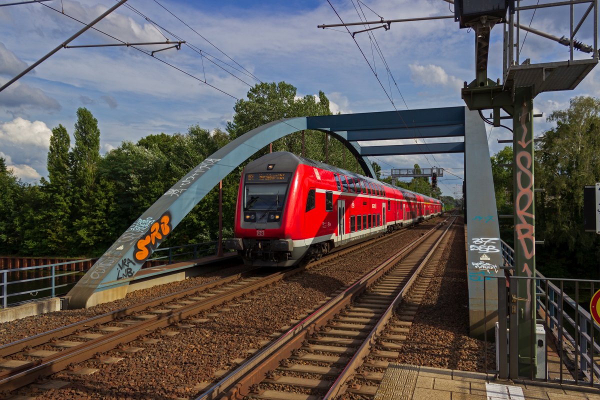 Ein Doppelstockzug der Linie RE1 �berquert das Flakenflie� in Erkner und f�hrt in den Bahnhof von Erkner ein.