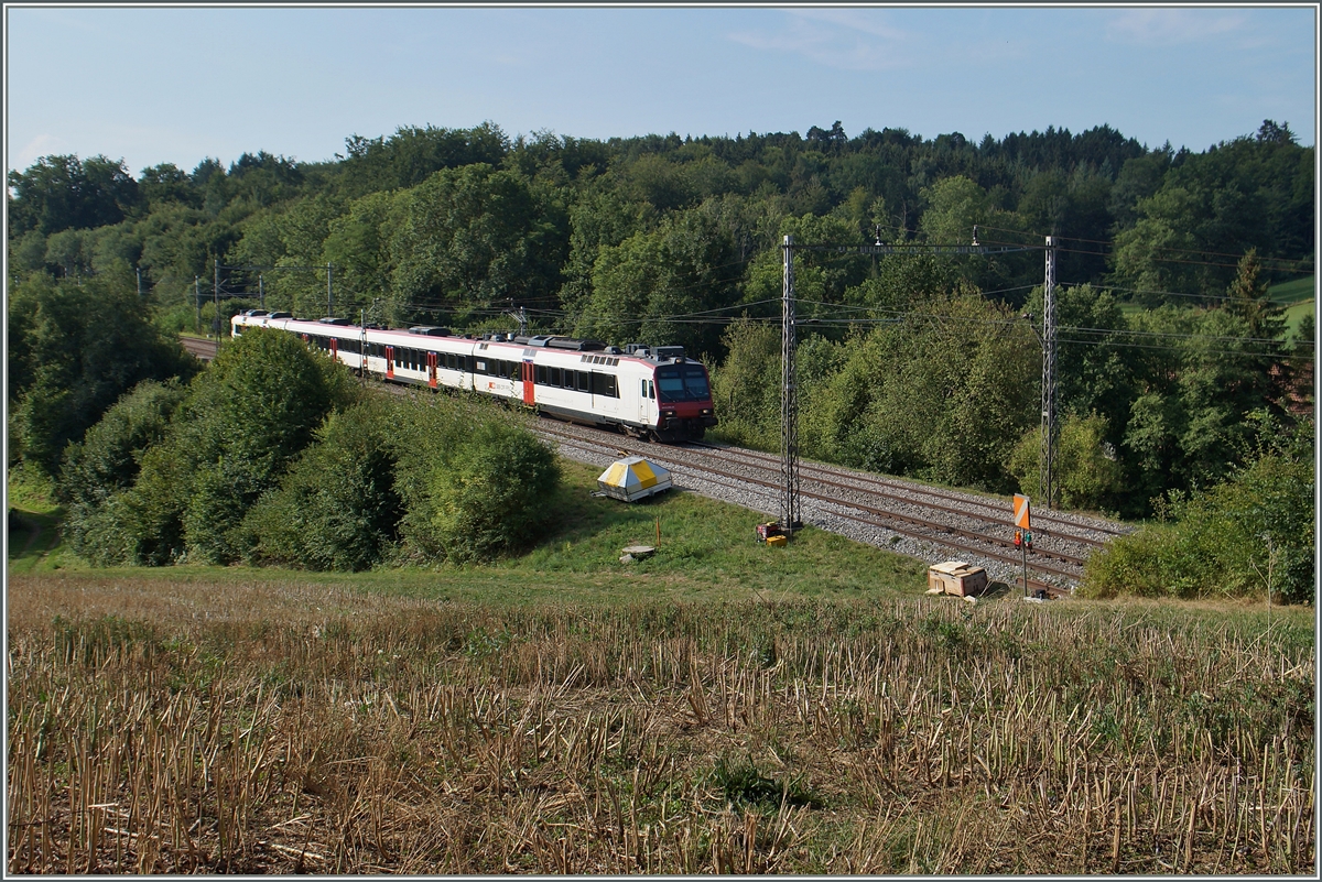 Ein SBB RBDe 560  Domino  als S 40 Romont - Bulle zwischen Neyruz und Rosé unter den wohl letzten alten Fahrleitnungsmasten zwischen St.Gallen und Genève. 
6 .August 2015