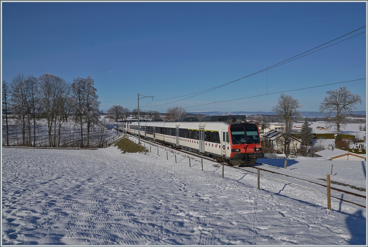 Ein tpf und ein SBB RBDe 560  Domino sind als RE 4016 von Düdingen nach Bulle unterwegs und erreichen in Kürze die Dienst- und Kreuzungsstation Vuisternens-devant- Romont. Weit im Hintergrund ist sogar noch der Jura zu erkennen. 

23. Dezember 2021