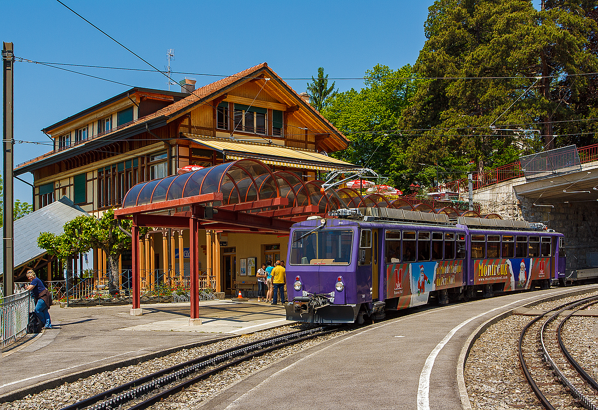 Ein Weihnachtsbild aus dem Mai.... 
Der Triebwagen Bhe 4/8 303 „Villeneuve“  der Transports Montreux-Vevey-Riviera (MVR), ex Chemin de fer Glion–Rochers-de-Naye (GN) am 26.05.2012 beim Halt auf der Talfahrt im Bahnhof Glion.

Auch wenn hier das Bild im Mai 2012 gemacht wurde, so passt es doch sehr gut in die jetzige Vorweihnachtszeit, man schaue auf den Weihnachtsmann am Triebwagen und die Aufschift:  „Le Monde Magique du Pére Noél” , nach meiner Übersetzung in Deutsch „Die magische Welt des Weihnachtsmannes“

Der Zahnradtriebwagen Beh 4/8 303 Villeneuve wurde 1983 von SLM (Schweizerischen Lokomotiv- und Maschinenfabrik) in Winterthur gebaut, der elektrische Ausrüstung wurde von Siemens (Werk Erlangen) geliefert.

Die Bhe 4/8 sind zweiteilige kurzgekuppelte elektrische Zahnrad-Doppeltriebwagen der Transports Montreux–Vevey–Riviera (MVR), ehemalig Chemin de fer Glion–Rochers-de-Naye (GN) und der Monte Generoso-Bahn (MG). Für die damalige GN wurden insgesamt 5 Stück gebaut (3 Stück 1983, und jeweils einer 1992 und 2011). Der 2011 gebaute wurde von der MOB Werkstätte Chernex gebaut. Bei den MVR Triebwagen wurden nachträglich Mehrfachsteuerung eingebaut, so können bis zu drei Triebwagen gekuppelt und gesteuert werden.

Bereits 1982 wurden anlässlich der Elektrifizierung der Monte Generoso-Bahn vier Triebwagen von der Schweizerischen Lokomotiv- und Maschinenfabrik (SLM) in Winterthur, für die MG, gebaut. Die elektrische Ausrüstung wurde von Siemens (Werk Erlangen) geliefert. Bei der Monte Generoso-Bahn sind die Triebwagen die einzigen elektrischen Fahrzeuge, zudem weichen die Technischen Daten der MG Fahrzeuge gegenüber der MVR Fahrzeuge leicht ab.


TECHNISCHE DATEN der MVR Bhe 4/8, in Klammern der MG Bhe 4/8:
Achsformel:  2'Z 2'Z + 2'Z 2'Z
Spurweite: 	800 mm
Länge über Puffer:  23.890 mm
Achsabstand im Drhgestell:2 .200 mm
Teilkreis-Ø vom Antriebszahnrad: 611 mm
Dienstgewicht:  34 t (34,1 t)
Höchstgeschwindigkeit:  22 km/h (bergauf) / 14 km/h (talfahrt)
Stundenleistung:  800 kW (1.088 PS) bei 15 km/h
Zahnradsystem: 	Abt
Stromsystem:  850 V DC 
Anzahl der Fahrmotoren: 4
Übersetzungsverhältnis: 1:12
Gefälle:  220 ‰
Sitzplätze: 	96
Klassen: 2. Klasse
