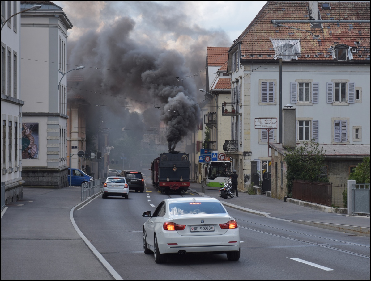 Eine etwas ungewöhnliche Verkehrsteilnehmerin in La Chaux-de-Fonds. 

Rette sich, wer kann. Denn CP E 164, heute bei La Traction, schnaubt mit viel Rauch als Geisterfahrerin die Rue du Manège hinauf. So sammeln sich respektvoll immer mehr Autofahrer auf der falschen Strassenseite. September 2021.