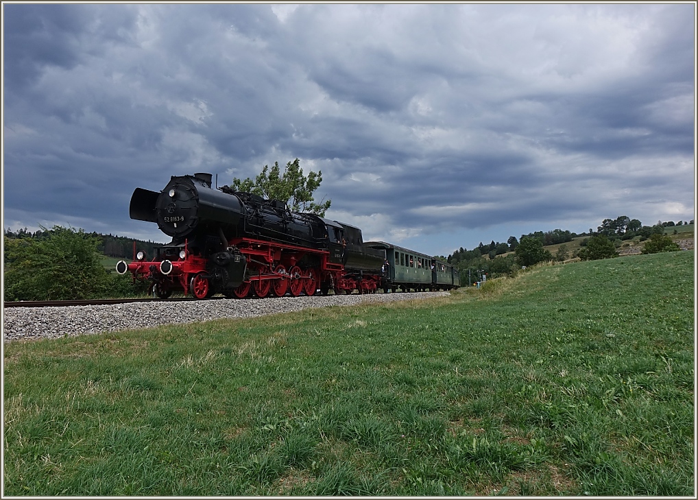 Eine Gewitterfront unterstreicht die mächtige Lokomotive ex DR 53 8163-9 auf ihrer Fahrt nach Les Hôpitaux - Neufs.
(15.07.2023)
