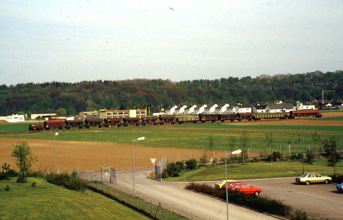 Eine Köf II als Streckenlok mit einem langen Güterzug auf der Illertalbahn im Mai 1983 bei Illertissen.