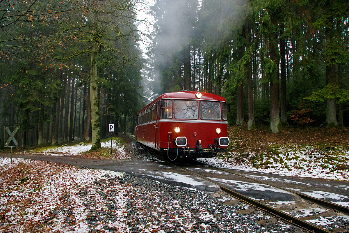 
Eine Schienenbusgarnitur der VEB Vulkan-Eifel-Bahn Betriebsgesellschaft mbH auf Sonderfahrt (bestehend aus 798 670-6, 998 863-5 und 796 784-7) fährt am 26.01.2019 zwischen der ehem. Grube Pfannenberger Einigkeit  (heute Sitz der Schäfer Werke) der Spitzkehre Pfannenberg. 

Die Garnitur befährt die priv. Strecke der Kreisbahn Siegen-Wittgenstein (Betriebsstätte Freien Grunder Eisenbahn - NE 447). Heute gibt es zwischen Herdorf und der Grube Pfannenberger Einigkeit noch jeden Werktag Güterverkehr, obwohl die Erzgrube Pfannenberger Einigkeit ihren Betrieb im April 1962 aufgegeben hat. An ihrer Stelle benötigen seitdem die Schäfer Werke KG den Anschluss für die Zulieferung von Stahl Coils sowohl als Rohstoff als auch für ihren Handel mit deren Zuschnitten nach Kundenwunsch.