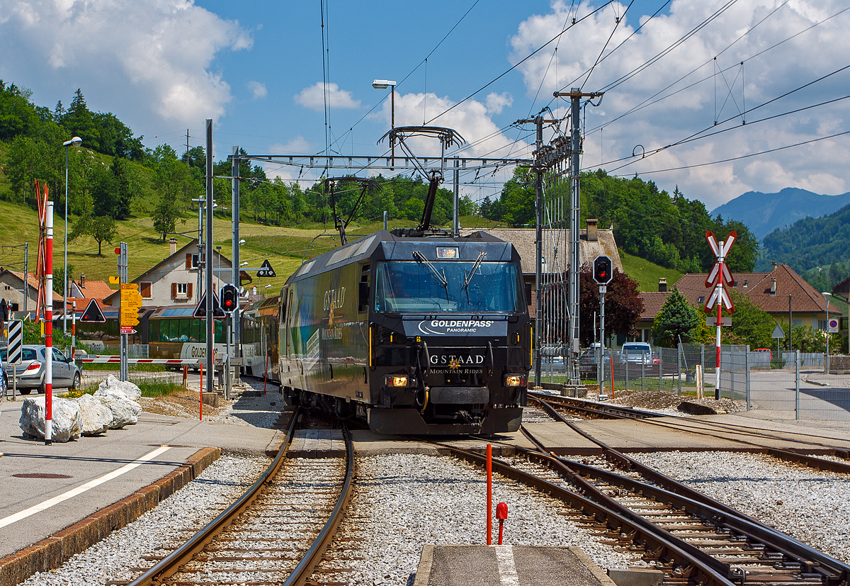 Einfahrt der MOB Ge 4/4 8001 mit dem Golden-Pass-Zug am 28.05.2012 in den Bahnhof Montbovon, mit diesen Zug fahren wir dann nach Zweisimmen. 2012 trug die 8001Werbung fr die Gstaader Tourismus-Organisation „Gstaad Mountain Rides“.  

Die Lok wurde 1994 von der Schweizerische Lokomotiv- und Maschinenfabrik (SLM) in Winterthur gebaut, die elektrische Ausrstung ist von ABB Verkehrssysteme AG. Die Ge 4/4 sind die leistungsstrksten schweizerischen Gleichstrom-Triebfahrzeuge. Die Maschinen der MOB (Montreux–Berner Oberland-Bahn) haben brigens keine Eigennamen oder Wappen, sie tragen nur die Betriebsnummer. Eine der vier Lok, die Lok 8003 wurde 2019 an die Rhtische Bahn verkauft und wurde dort zur RhB Ge 4/4 653 umgebaut.

Die vier 1994 von SLM und ABB fr die MOB gebauten Ge 4/4 hneln sowohl optisch als auch mechanisch den Ge 4/4 der Bire-Apples-Morges-Bahn (BAM) und den Ge 4/4 III der Rhtischen Bahn (RhB). Der elektrische Teil musste jedoch dem Betrieb ab Fahrleitung mit 900 V Gleichspannung angepasst werden und eine allfllige Umrstung auf Zweisystem-Betrieb mit zustzlich 15 kV 16,7 Hz bercksichtigen. Der Betrieb mit Wechselspannung wre notwendig gewesen, wenn die GoldenPass-Linie mit einer dritten Schiene bis Interlaken verlngert worden wre. So ist im Lokkasten bereits der Platz fr einen Transformator fr den Betrieb bei 15 kV mit 16 2/3 Hz Wechselstrom vorgesehen, ebenso lsst sich ein dritter Pantograph nachrsten.

Die Lok ist mit vier Schnellschaltern ausgerstet, die ber Drosseln die wassergekhlten Stromrichter versorgen. Die Eingangsspannung der Wechselrichter kann von 630 bis 1080 Volt variieren, fr den Zweispannungsbetrieb htte die Zwischenkreisspannung 1350 Volt betragen. Dies erforderte eine Anpassung der Fahrmotorwicklung gegenber den RhB-Loks, die fr eine Zwischenkreisspannung von 2100 bis 2800 Volt ausgelegt sind. Der mechanische Teil des Fahrmotors ist baugleich mit demjenigen der RhB-Motoren.

Die Loks haben eine Leistung von 2000 kW und erreichen eine Hchstgeschwindigkeit von 120 km/h, die jedoch im Normalbetrieb mangels geeigneter Strecken nicht erreicht wird. Wegen der relativ geringen Spannung sind sehr hohe Stromstrken erforderlich. Daher fahren die Loks der Montreux–Berner Oberland-Bahn (MOB) immer mit zwei Stromabnehmern am Fahrdraht. Zudem sind die Stromabnehmer mit drei statt den blichen zwei Schleifleisten versehen, was man hier im Bild auch gut sehen kann.

Mglich ist auch die Vielfachsteuerung mit den MOB GDe 4/4, was erst erforderlich ist, wenn mehr als sechs Panoramawagen zu befrdern sind. Dies ist bisher nur vereinzelt vorgekommen.

Die Loks hatten (wie im Bild auch zu sehen) Mittelpuffer mit einer Schraubenkupplung, ab 2017 wurden die drei bei der MOB verbliebenen Loks auf automatische Mittelpufferkupplung (Schwab-Kupplung) umgebaut. Seit 2020 sind die verbliebenen 3 Lokomotiven mit allen Fahrzeugen Steuerwagen sowie den Triebwagen mit Schwab-Automatikkupplung in Vielfachsteuerung kompatibel und

TECHNISCHE DATEN:
Gebaute Anzahl: 4, die Ge 4/4 8003 wurde 2019 an die RhB verkauft. 
Hersteller mech. Teil: SLM, Winterthur 	  	
Elektr. Ausrstung: ABB Verkehrssysteme AG
Spurweite: 1.000 mm (Schmalspur)
Achsfolge: Bo'Bo'
Lnge ber Puffer: 16.100 mm 
Treibraddurchmesser: 1.070 mm (neu)
Breite max.: 2.800 mm
Hhe : 3.860 mm 	  	
Dienstgewicht: 63 t
Anzahl der Fahrmotoren:  4
Maximale Leistung am Rad:	2.400 kW 	 
Dauerleistung am Rad: 2.000 kW 	  	 
Dauerzugkraft am Rad: 150 kN
Anfahrzugkraft am Rad:  200 kN
Hchstgeschwindigkeit: 120 km/h 	  
Anhngelast bei 45 km/h und 73‰ Steigung: 170 t
Anhngelast bei 80 km/h und 25‰ Steigung:	300 t
Stromsystem: 900 V DC (Gleichstrom)
Strombertragung: 2 Einholmstromabnehmer mit je 3 Schleifleisten
