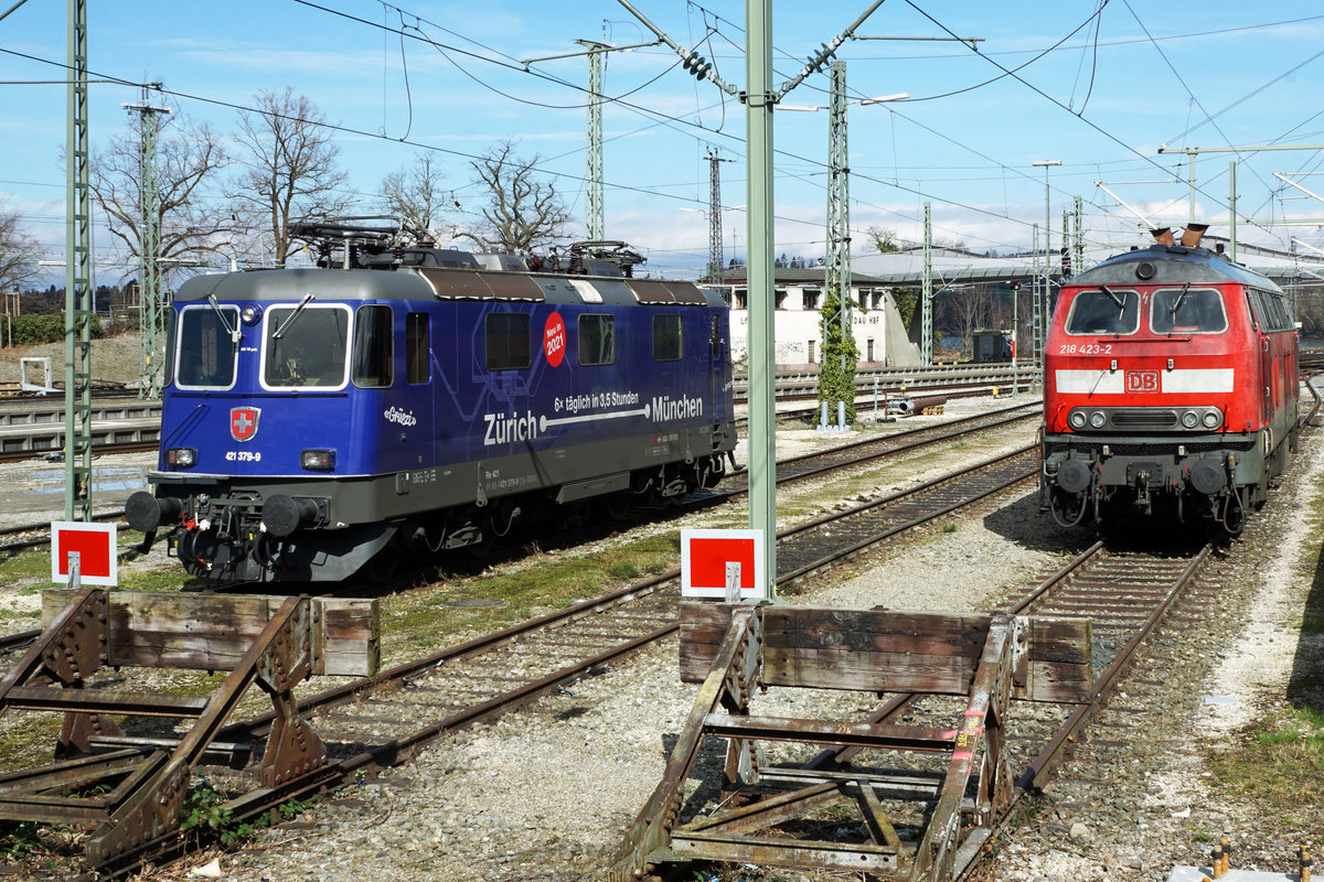 Einschränkung im Bahnverkehr wegen dem Coronavirus.
Betroffen ist auch der
EC ZÜRICH-MÜNCHEN voraussichtlich bis zum 26. April 2020.
Am 12. März 2020 standen die Re 421 394-8 sowie die Re 421 379-9 mit dem Werbeanstrich für die schnellere Verbindung von Zürich HB nach München im Einsatz.
Nach der Aufhebung vom Bahnersatz verkehren seit wenigen Tagen die Züge wieder bis zum Bahnhof Lindau.
Die SBB Re 421 379-9 sowie die DB BR 218 423-2 warten in Lindau gemeinsam auf den nächsten Einsatz.
Fotostandort Angestelltenparkplatz hinter den Prellböcken, Bildausschnitt Fotoshop. 
Foto: Walter Ruetsch 