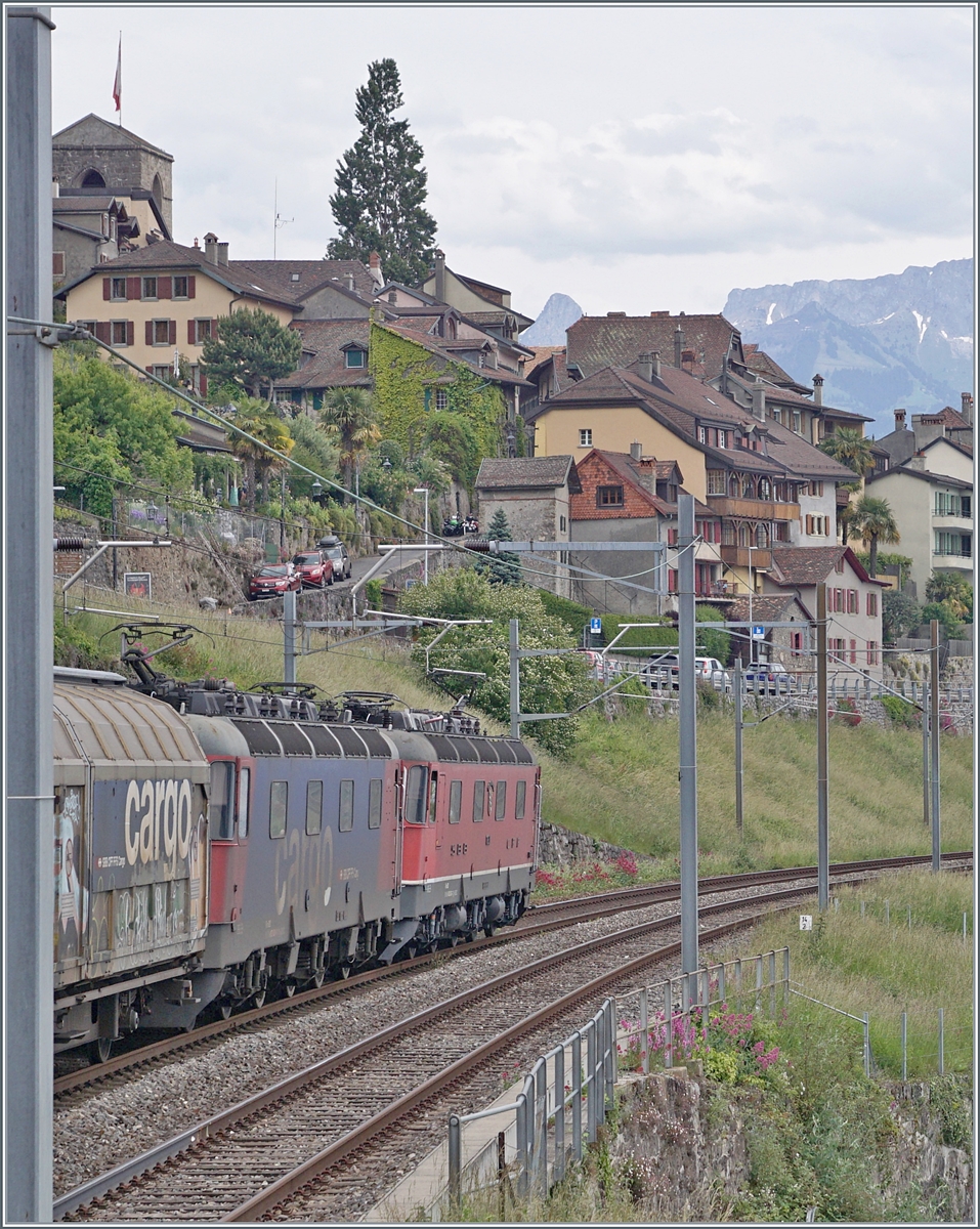 Erneut mit zwei Re 6/6 bespannt ist zwischen Rivaz und St-Saphorin ein SBB Cargo Güterzug in Richtung Wallis unterwegs. An der Zugsspitze führt die rote SBB Re 6/6 11630 (Re 620 91 85 4 620 030-7 CH SBBC)  Herzogenbuchsee den Zug und dahinter hilft die Re 6/6 11624  Rothrist . Die Re 676 11630 hatte ich bereits am Vormittag mit dem Kesselwagenzug fotografieret. 16. Mai 2025