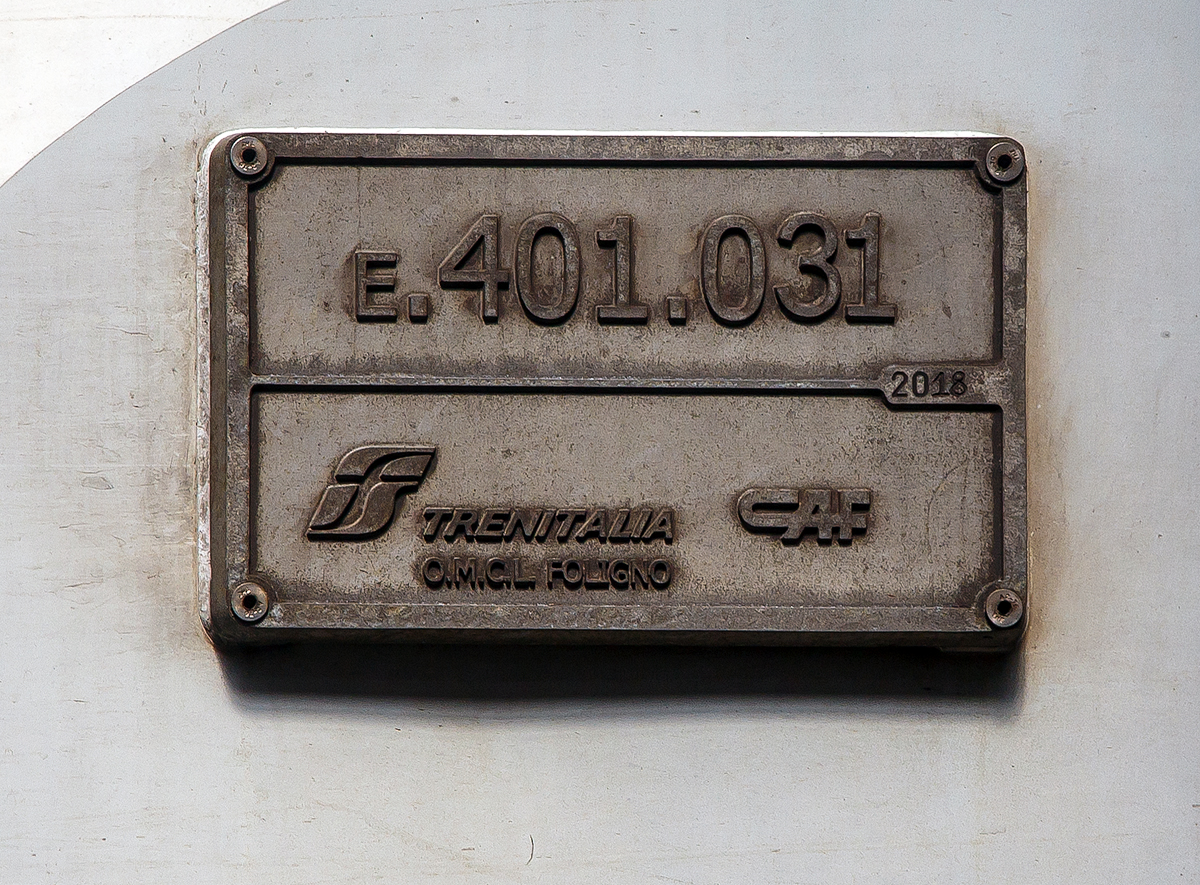 Fabrikschild (vom Umbau) der Trenitalia E.401.031 (ex FS E.402.03) am im Bahnhof Milano Centrale (Mailand Hbf).