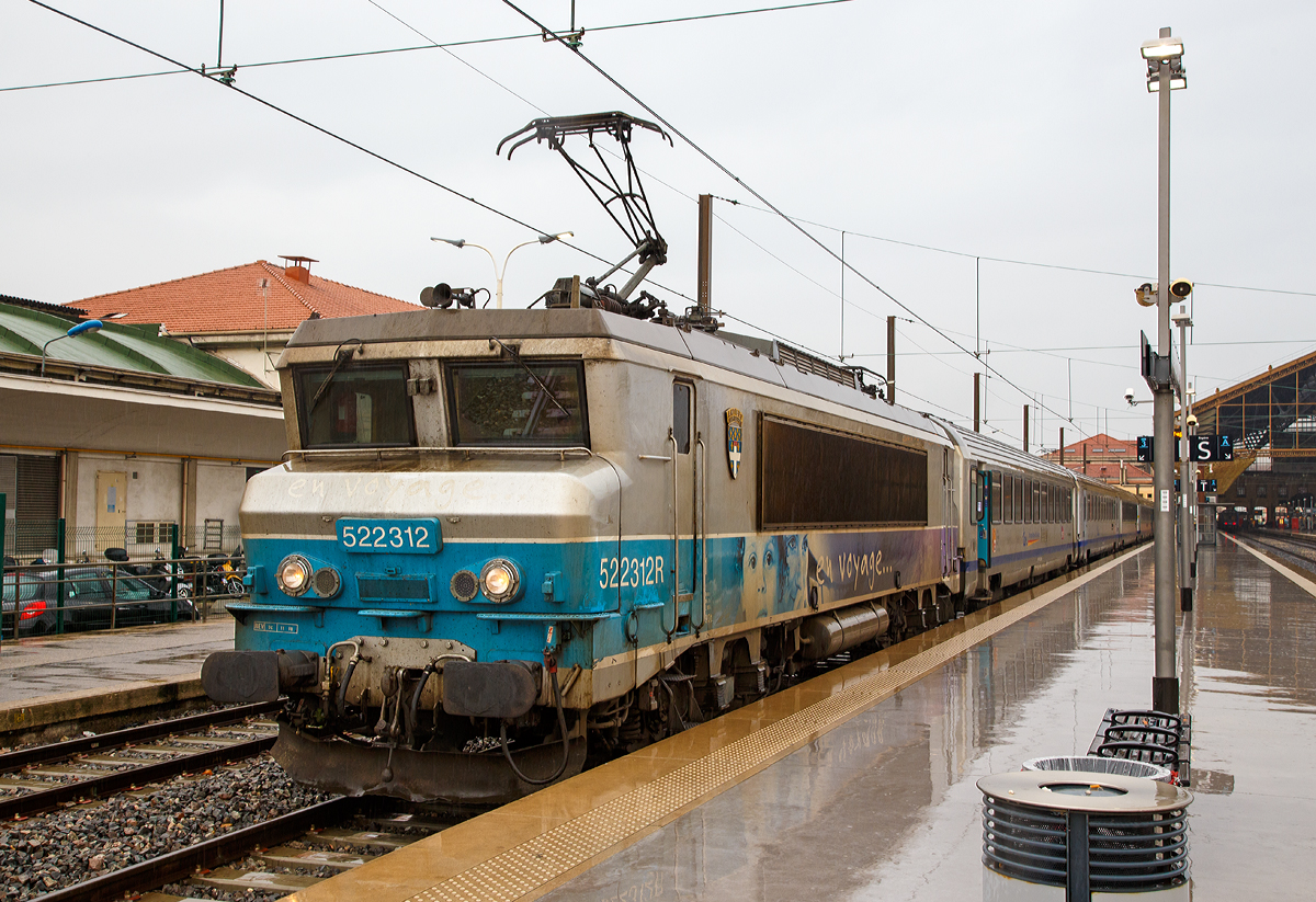 
Für Jeanny, eine nez cassé en livrée  En Voyage....  
Die SNCF BB 22312  Antibes / Juan-les-Pins  (BB 522312R bzw. UIC: F-SNCF 91 87 0022 312-) steht am 25.03.2015 mit einem TER Regionalzug im Bahnhof Marseille Saint-Charles bereit. 

An Hand der ersten Ziffer vor der Loknummer (5), kann man die die Zugehörigkeit zum Geschäftsbereich der SNCF erkennen, die  5  steht für TER (Regionalverkehr). 
Mit der Aufgliederung der SNCF in verschiedene Geschäftsbereiche wurde der Bestand zum 1. Januar 1999 aufgeteilt, die Zugehörigkeit kann man an der ersten Ziffer erkennen:
1 = VFE (Fernverkehr),
2 = CIC (überregionaler Personenverkehr),
4 = Fret (Güterverkehr)
5 = TER (Regionalverkehr)
6 = Infra (Betrieb und Unterhaltung)
7 = Dirction du Material (Materialwirtschaft)
8 = Transilien (Vorortverkehr im Großraum Paris)

Das  R  hinter der Loknummer zeigt dass diese Lok Wendezugtauglich ist. Ab 2006 wurden einige BB 22200 mit Wendezugsteuerungen versehen, zur Kennzeichnung, wurde wie bei dieser, der Loknummer das  R  (R = réversible) nachgesetzt. 

Die Lok  BB 22312 trägt das Wappen der französischen Stadt Antibes / Juan-les-Pins, diese liegt an der Eisenbahnstrecke von Marseille nach Monaco (zwischen Cannes und Nizza) an der Côte d’Azu. Juan-les-Pins ist ein Seebad an der Côte d’Azur. Der Ort gehört zur Gemeinde Antibes und liegt im Département Alpes-Maritimes in der Région Provence-Alpes-Côte d’Azur.