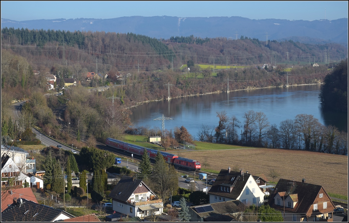 Godot-Express rechts des Hochrheins.

Eine BR 245 mit 3 Dostos. Karsau, Dezember 2021.

An jeder Station wird neuerdings erneut auf Godot gewartet. Er könnte ja noch kommen, auch wenn ihn bis heute niemand gesehen hat. Reisen im 612 war gestern, heute heißt es durch die Landschaft bummeln. Beachtenswert noch: Entgegen der Versprechung leichter und schneller Einstieg fährt hier ein Hocheinstiegsdosto mit. Sehr geschickt bei den besseren Bordsteinen in den Bahnhöfen der Hochrheinbahn. So macht es keinen Unterschied zu den Einstiegszeiten der 612er.