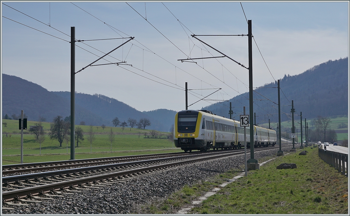 Gut zehn Jahre später an der praktisch gleichen Stelle hat sich die Szenerie merklich geändert: Zwar wählte ich erneut eine Gegenlichtsituation, und Bäume und Berge sind weiterhin an ihrer Stelle, doch die Strecke wurde auf zwei Spuren erweitert und elektrifiziert. 
Erst auf den zweiten Blick fällt auf, dass die vorher nördlich der Strecke gelegene Strasse nun südlich liegt und der ehemalige Bahnübergang im Hintergrund durch eine Brücke ersetzt wurde. 

Die beiden DB 612 067 und 612 572 sind als IRE 3042 von Friedrichshafen nach Basel Bad Bf unterwegs und erreichen in Kürze den Bahnhof von Neunkirch, wo der IRE jedoch ohne Halt durchfährt. 

25. März 2021