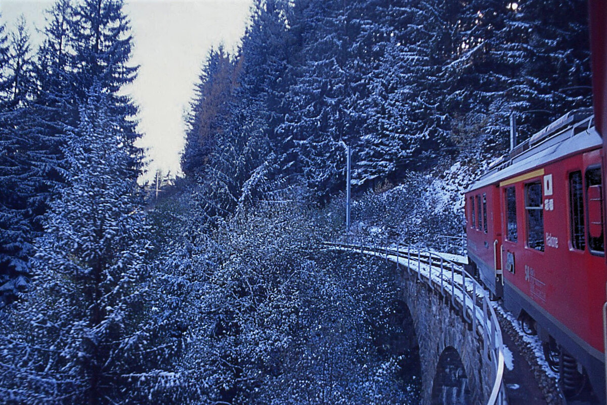 Hinter dem Triebwagen ABe 4/4 54  Hakone  im Aufstieg auf der Berninastrecke nach Cadera. Der Triebwagen trägt das japanische Wappen, und die Aufschriften  HAKONE  und - in japanischer Schrift -  箱根 (Hakone). Aufnahme 29.Oktober 1997 