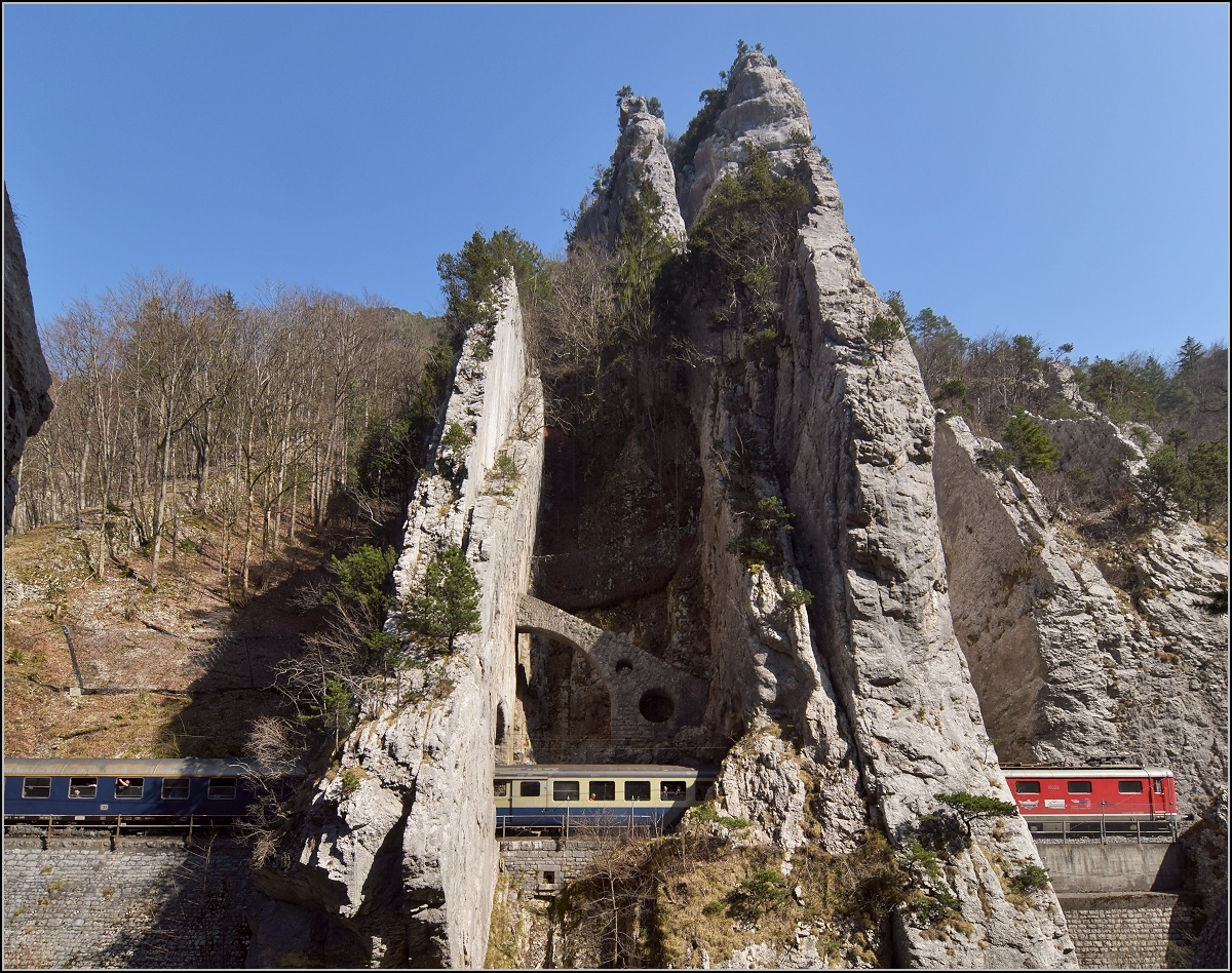 IGE-Abschiedsfahrt vom  Blauen Fernschnellzug . 

Durchfahrt der bekannten Juraklus bei Moutier/Münster. Re 4/4 I 10009 ist am Zugschluss, im Fenster ein ehemaliger BLS-Wagen und davor ein blauer Schnellzugwagen der DB. März 2019.
