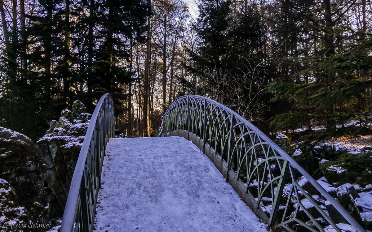 Im Kasseler <u><a href= http://www.unesco.de/kultur/welterbe/welterbestaetten/welterbe-deutschland/bergpark-wilhelmshoehe.html  target= _blank >Bergpark Wilhelmshöhe</a></u> führt diese kleine Brücke über einen Wasserfall an einem künstlichen Felshang. Der gesamte Park ist ein barockes Gesamtkunstwerk der Garten- und Landschaftsgestaltung. (06.01.2017)