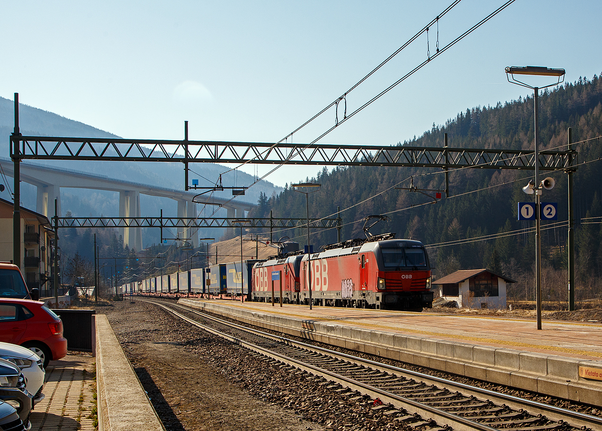 In Doppeltraktion fahren die beiden ÖBB Vectron MS 1293 043-6 und 1293 037-8 am 28.03.2022 mit einem langen „LKW-Walter“-KLV-Zug durch den Bahnhof Gossensaß/Colle Isarco zum Brenner/Brennero hinauf.

Im Hintergrund das Wipptal überbrückende Gossensaß-Viadukt (Viadotto Colle Isarco) der Brennerautobahn. Noch fahren auf der Brennerautobahn teilweise LKW an LKW, mit der 2032 geplanten Eröffnung von dem 64 km langen Brennerbasistunnel (BBT), soll dies dann vorbei sein. Dann ist man mit der Bahn von München viel schneller in Verona oder Venedig, aber dann ist für uns Bahnfotografen auch nichts mehr viel los auf der Brennerbahn (Ferrovia del Brennero).
