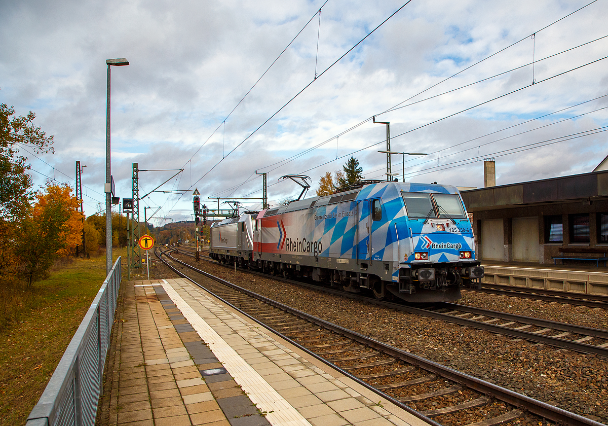 In Doppeltraktion TRAXX F140 AC2 mit AC 3 (BR 185.2 und 187).....
Die beiden Loks der RheinCargo GmbH & Co. KG fahren am 26.10.2021 als Lz (Lokzug) bzw. Tfzf (Triebfahrzeugfahrt) in Doppeltraktion durch den Bahnhof Amstetten (Württ.) in Richtung Ulm.

Vorne die 185 350-6 mit Werbung „Grenzenlos für sie im Einsatz“ (91 80 6185 350-6 D-RHC), ex DB Cargo 185 350-6, eine TRAXX F140 AC2 und dahinter die 187 072-4 (91 80 6187 072-4 D-RHC), eine TRAXX F140 AC3 (ohne LM). 

Die185 350-6 wurde 2008 von Bombardier in Kassel unter der Fabriknummer 34250 gebaut und die DB Cargo (damals Railion) geliefert, 2019 wurde sie an die RheinCargo GmbH & Co. KG verkauft. Hinten die 187 072-4 eine TRAXX F140 AC3 ohne LM wurde 2016 von Bombardier in Kassel unter der Fabriknummer 35251 gebaut und an die RheinCargo GmbH & Co. KG geliefert.