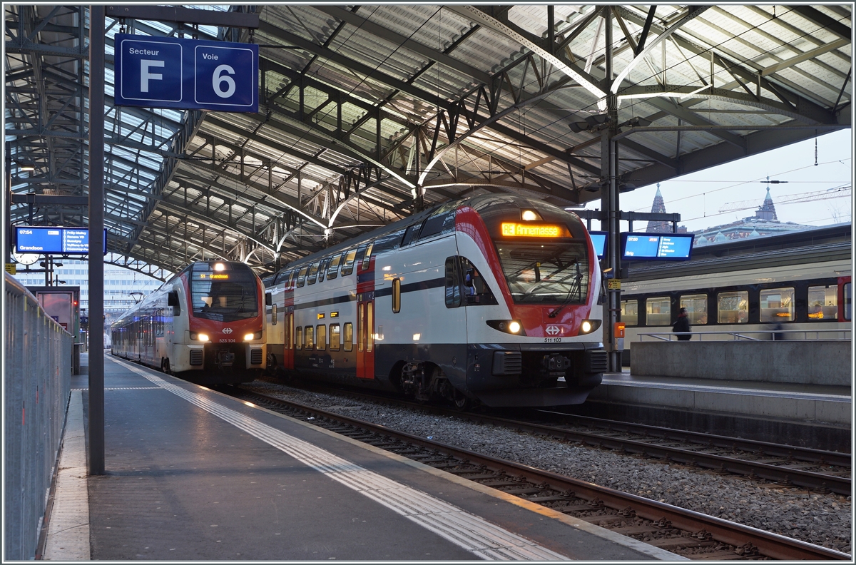In Lausanne steht der SBB RABe 511 103 als RE nach Annemasse und der SBB RABe 523 104 als S1 nach Grandson. An diesem Wochenende (wie auch am vorhergehenden) wurden infolge von Weichenerneuerungen in Lausanne weitreichende Fahrplanänderungen nötig, da in Lausanne nur noch die Gleise 1 (von und nach Bern) sowie 7 und 8 (von und nach dem Wallis) durchgehend befahrbar waren. Alle anderen Gleise konnte Baustellenbedingt nur als Kopfgleise genutzt werden.

21. Nov. 2021
