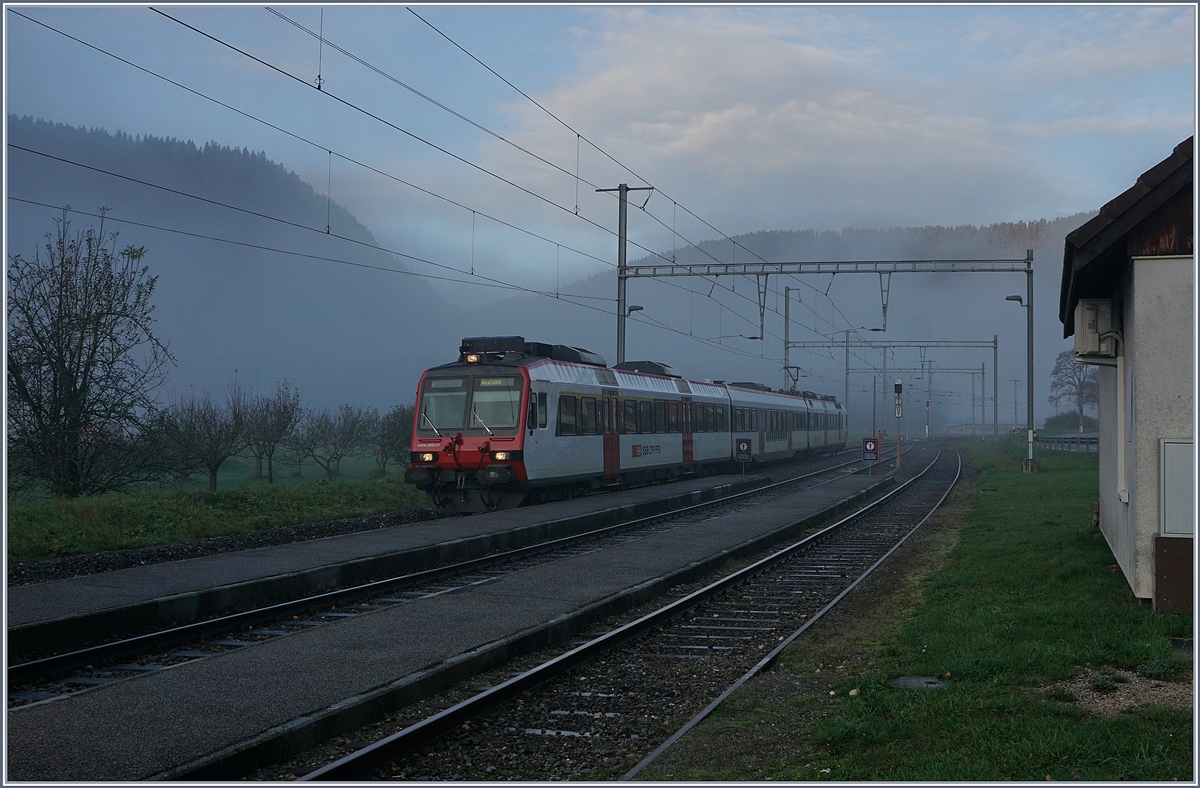 In der nebligen Morgendämmerung erreicht ein SBB RBDe 560 Pendelzug von Buttes nach Neuchâtel den Bahnhof Noiraigue. 

5. Nov. 2019