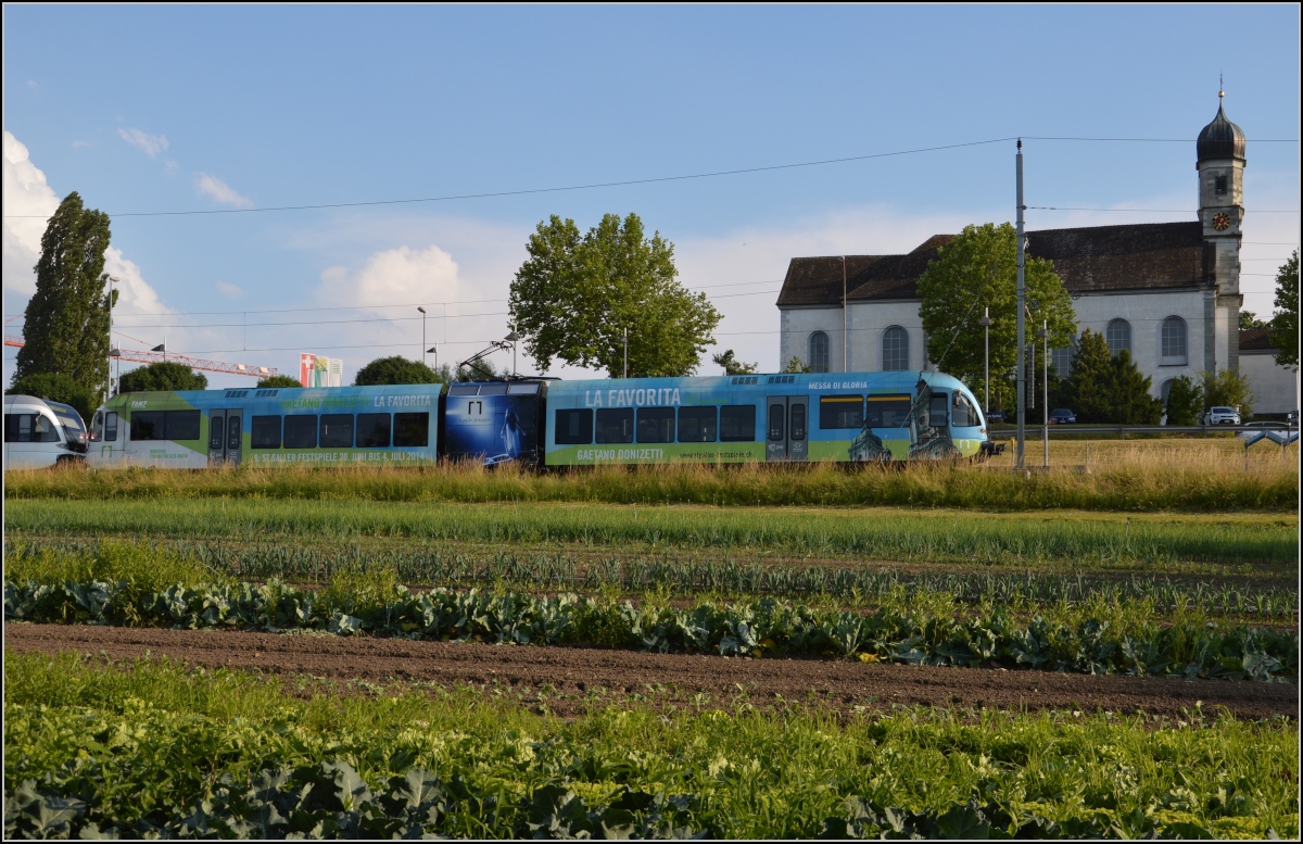 Ins rechte Licht gesetzt macht auch ein GTW was her. 

Thurbo GTW 2/8 vor der Klosterkirche des Spitals Münsterlingen. Juni 2014.