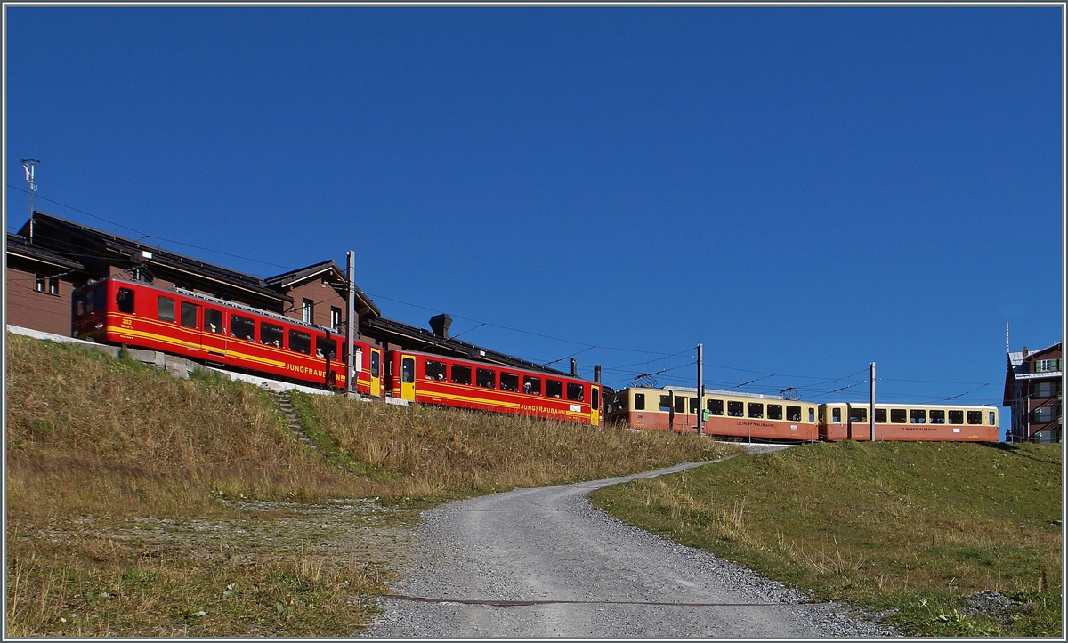 Klassische Jungfraubahn-Züge in neuer und alter Farbgebung warten auf der Kleinen Scheidegg auf die Abfahrt. 
9. Okt. 2014 