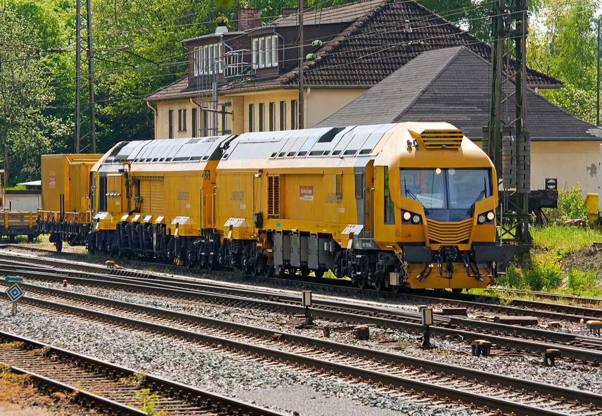 LINSINGER Rail milling train MG31 (Schienenfrszug MG 31), Schweres Nebenfahrzeug Nr. D-DB 99 80 9427 009-2, der DB Bahnbau Gruppe GmbH steht am 04.05.2014, mit dem Gertewagen 40 80 3302 203-4 Ks, in Kreuztal. 
Leider war eine Aufnahme nur von der Schattenseite mglich. 

Der Schienenfrszug MG 31 wurde 2012 von LINSINGER Austria Maschinenbau Ges. m.b.H. in Steyrermhl (sterreich) entwickelt und gebaut. Auf der InnoTrans 2012 wurde er erstmals der ffentlichkeit vorgestellt.

Technische Daten: 
Spurweite: 1.435 mm  
Achsanzahl: 24 (je 3 Achsen in 4 Drehgestelle) 
Achsfolge: unbek. 
Lnge ber Puffer: 23.800 mm/Einh. = 47.600 mm 
Ges. Drehzapfenabstand: 15.300 mm 
Eigengewicht: 183 t 
Zur Mitfahrt zugel Personen: 5 
Hchstgeschwindigkeit: 100 km/h 
Zugelassen fr Streckenklasse: CE und hher und CM4 
Kleister befahrbarer Gleisradius: 150 m
Anzahl der Bearbeitungseinheiten : links und rechts je 3 Frseinheiten, sowie je eine Schleifeinheit links und rechts
Weitere Daten sind mir noch unbekannt.
