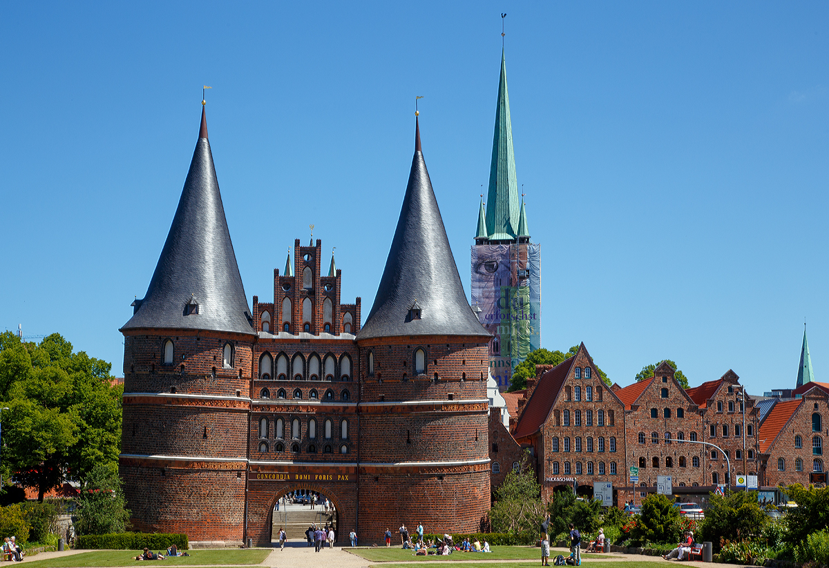 
Lübeck am 11.06.2015, blick auf das Holstentor von Westen (Feldseite) in Richtung der Altstadt. Rechts der (z.Z. verhüllte) Turm der Petrikirche, davor die historischen Salzspeicher. 

So schön gerade, wie wir von dem Stich, des Holstentors der sich auf der Rückseite 50-DM-Scheine befand ist es nicht- Daher ist mir hier auch das Ausrichten sehr schwer gefallen.