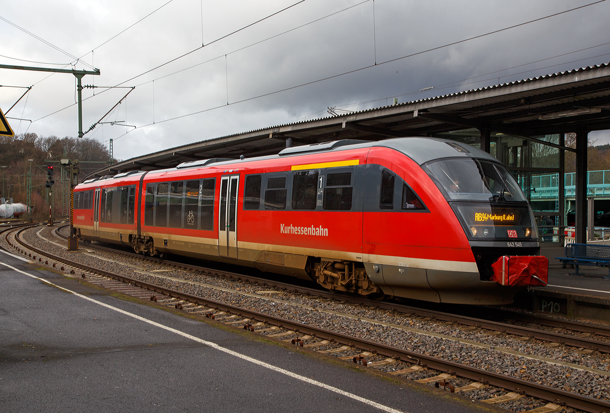 
Mit dem Fahrplanwechsel am 15. Dezember 2019 kommen nun auch Siemens Desiro´s nach Betzdorf (Sieg)....
Der VT 642 545 / 642 045 (95 80 0642 545-7 D-DB ABp / 95 80 0642 045-8 D-DB Bpd), ein Siemens Desiro Classic der Kurhessenbahn, steht als RB 94 „Obere Lahntalbahn“ (Umlauf 23196/23169, Zuglauf Betzdorf - Siegen - Kreuztal - Erndtebrück - Bad Laasphe - Biedenkopf - Marburg a.d. Lahn), zur Abfahrt bereit.

Ab dem 15. Dezember 2019 werden die Universitätsstädte Marburg (Lahn) und Siegen - Betzdorf (Sieg) per Direktverbindung vernetzt, um das Angebot attraktiver zu gestalten und die Angebotsnachfrage einzuschätzen. Vorerst werden an Samstagen zwei Züge der Kurhessenbahn, Linie RB 94, in beide Richtungen von Marburg nach Betzdorf (Sieg) über Bad Laasphe, Erndtebrück, Kreuztal und Siegen durchgebunden. Die anderen Züge der Oberen Lahntalbahn (Linie RB 94) fahren zwischen Marburg (Lahn) und Bad Laasphe sowie Erndtebrück. Ein Umstieg in Erndtebrück zur Weiterfahrt nach Siegen bzw. Betzdorf entfällt mit den neuen Direktverbindungen an Samstagen.
Die Züge fahren um 8.24 und um 14.24 Uhr von Marburg nach Siegen sowie um 12.59 und um 18.59 Uhr von Siegen nach Marburg. Der Markttest ist zunächst auf zwei Jahre begrenzt.

Es gibt nur einen kleinen Nachteil, die Reise ab Betzdorf dauert fast 3 Stunden (genau 2:54), über Gießen ist man unter 2 Stunden dort, man muss dann halt nur zweimal umsteigen.



Die Baureihe 642 (Siemens Desiro Classic):

Der hier gezeigte Dieseltriebzug wurde 2000 von Siemens in Uerdingen unter den Fabriknummern 91617 und 92077 gebaut. Bis 2017 war sein BW Leipzig, nun fährt er für die Kurhessenbahn (DB Regio).


Ende der 1990er Jahre schrieb die DB eine größere Anzahl von Dieseltriebwagen aus, mit dem Ziel, den Betrieb auf Nebenbahnen wirtschaftlicher zu gestalten und dort die verbliebenen lokbespannten Züge abzulösen. Es wurden gut 500 Triebwagen, aufgeteilt in acht Baureihen, bei der Fahrzeugindustrie bestellt. Die stückzahlenmäßig größte Baureihe war der Desiro von Düwag bzw. Siemens, er wurde als Baureihe 642 in 231 Exemplaren beschafft.


Technik und Aufbau:
Der Wagenkasten ist aus selbsttragenden Aluminiumröhre in Integralbauweise konstruiert. Die Kopfteile mit den Führerständen sind als vorgefertigte GfK-Module ausgeführt, die auf das verlängerte Untergestell des Aluminiumwagenkastens aufgeklebt sind.

Der Fahrgastraum ist gegliedert in den Niederflurbereich (von einem Einstieg bis zum Sitzbereich über dem Jakobsdrehgestell) und die höher gelegenen Bereiche an jedem Wagenende. Aufgrund des vergleichsweise großen Motorraums besitzt die Baureihe 642 jedoch einen geringeren Niederfluranteil als vergleichbare Züge wie zum Beispiel Bombardier Talent oder Alstom Lint. Glaswände und -türen trennen Einstiegsräume und Übergangsbereiche voneinander ab.

Der Fahrgastraum wird durch eine Warmwasser-Umluft-Heizung, bei extremer Kälte durch Ölfeuerung geheizt. Im Sommer soll die Klimaanlage für behagliche Temperaturen sorgen, allerdings sind die Anlagen noch immer störanfällig. Pro Wagen können sechs Fenster gekippt werden.


Fahrwerke und Bremsen
Zwei angetriebene Drehgestelle, ein nicht angetriebenes Jakobsdrehgestell mit Gummiprimärfedern und niveauregulierter Luftfederung in der Sekundärstufe. Je drei Wellenbremsscheiben
je Triebdrehgestell, zwei Radbremsscheiben je Radsatz im Jakobsdrehgestell. Magnetschienenbremse in den Triebdrehgestellen. Mikroprozessorgesteuerter Gleit- und Schleuderschutz. Die Triebwagen sind mit einer direkten elektropneumatischen Bremse (ep-Bremse) und einer indirekten mehrlösigen Druckluftbremse als Rückfallebene ausgestattet. Mit dem Retarder wird bei Nutzung der ep-Bremse zudem hydrodynamisch gebremst. Als Feststellbremse sind Federspeicherbremsen vorhanden. Die Magnetschienenbremse kommt bei Zwangs- und Schnellbremsungen zum Einsatz, bei Notbremsungen jedoch bleibt sie unwirksam. Zudem kann sie vom Triebfahrzeugführer über einen Kippschalter zugeschaltet werden.

Antrieb
Der Triebzug wir von zwei MTU 6-Zylinder-Dieselmotor mit Abgasturboaufladung, Ladeluftkühlung mit jeweils 275 kW / 374 PS Leistung (Euro II) bei 1900 U/min angetrieben. (Bei anderen Kunden und Ausführungen auch 315, 335 oder 360 kW, sowie Motoren von MAN)
Diese befinden sich jeweils unter dem Hochflurbereich zwischen dem angetriebenen Drehgestell und dem Niederflurbereich. Ihr Drehmoment wird über ein hydromechanisches Fünfgang-Automatikgetriebe mit Anfahrwandler und integriertem Retarder auf das äußere Drehgestell übertragen.

Technische Daten (DB Regio Version) : 
Spurweite:  1.435 mm (Normalspur)
Achsformel:  B´2´B´
Länge über Kupplung:  41.700 mm
Drehzapfenabstand: 2 x 16.000 mm
Achsabstand im Drehgestell: 1.900 / 2.650 /1.900 mm
Lauf- und Treibraddurchmesser: 770 mm (neu) / 710 mm (abgenutzt)
Breite:  2.830 mm
Größte Höhe: 3.819 mm
Fußbodenhöhen: 1.250 mm (Hochflur) / 575 mm (Niederflurbereich)
Eigengewichtgewicht: 68,2 t
Zul. Gesamtgewicht:  88,7 t
Höchstgeschwindigkeit:  120 km/h
Motoren: zwei MTU 6-Zylinder-Dieselmotor 
Leistung: 2 x 315 kW 
Kraftübertragung: mechanisch (5-Gang-Automatikgetriebe mit hydraulischen Anfahrwandler)
Kraftstoffvorrat:  2 x 600 l
Heizölvorrat:  2 x 150 l
Max. Anfahrbeschleunigung: 1,1 m/s²
Max. Bremsverzögerung: Betriebsbremse 0,9 m/s² / Gefahrbremse 1,15 m/s²
Sitzplätze: 12 (1.Klasse) 109 (2.Klasse, davon 13 Klappsitze)
Stehplätze:  90
Scharfenberg Kupplung:  Typ 10
