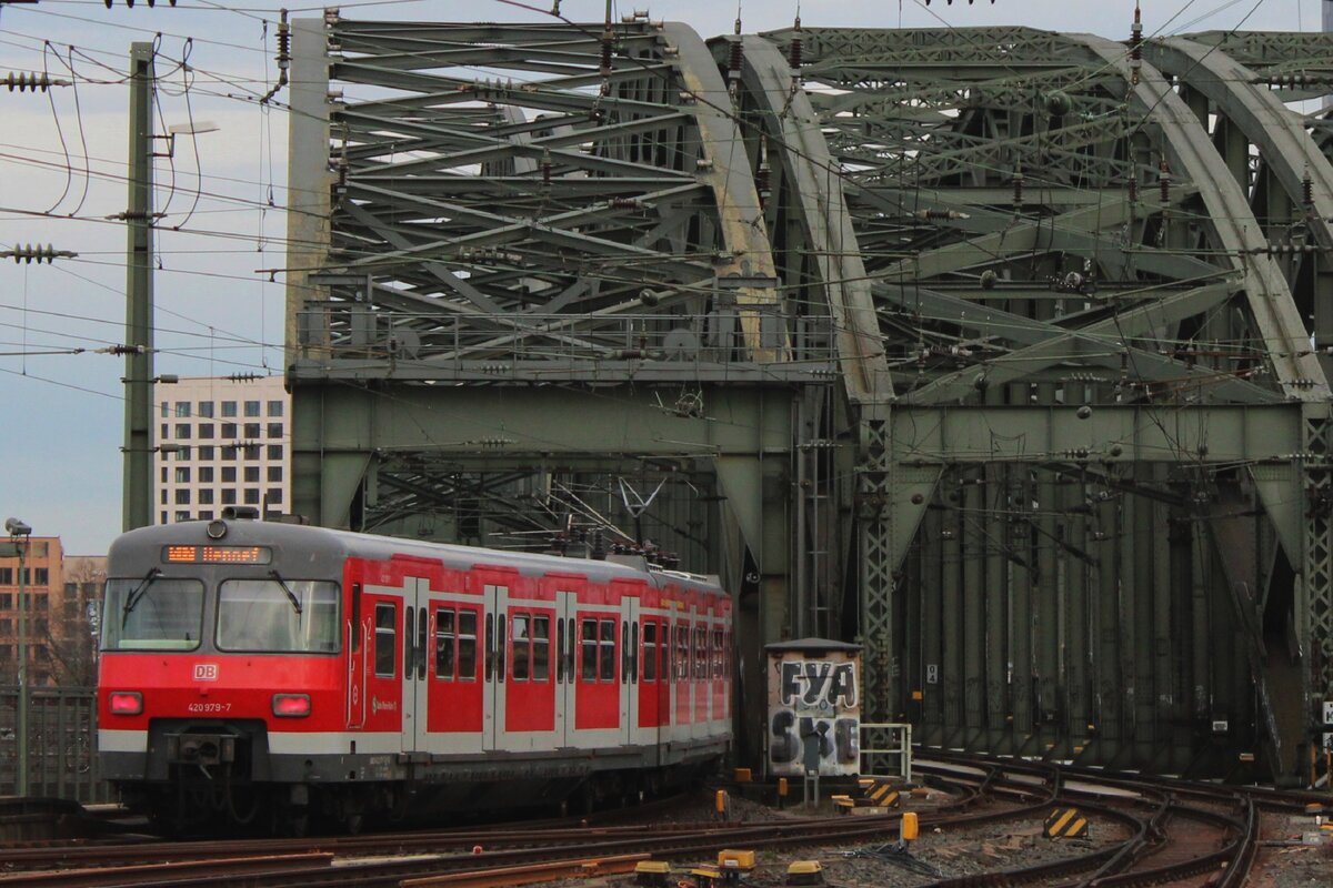 Mit etwas Zooming mit der Kamera kann Mann vom Bahnsteig in Köln Hbf Tirebzüge nach/von die Hohenzollernbrücke fotografieren, wie am 15 Februar 2024 DB 420 979 unter Beweis stellt. 