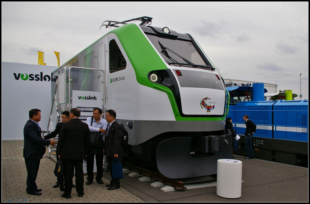 Mockup der Vossloh EURO Dual auf der InnoTrans 2014 in Berlin. Bei dem Loktyp handelt es sich um eine Dual-Mode-Lok mit Elektro- und Dieselmotor. Die EURO Dual basiert auf den beiden Familien EURO 4000 und EUROLight. Angeboten wird die Lok mit drei Diesel-Traktionsklassen (700 kW, 1400 kW und 2800 kW) und elektrisch bis 6000 kW. Die Höchstgeschwindigkeit liegt bei 120 km/h.

Webseite Hersteller (deutsch): http://www.vossloh-innotrans.com/cms/de/produkthighlights/diesellokomotiven/dual_mode_lokomotiven/dual_mode_lokomotiven_1.html