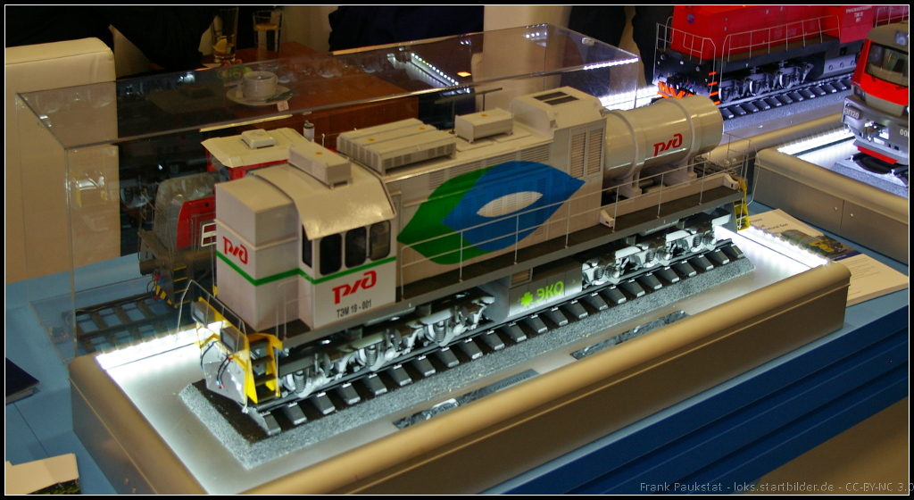 Model of TEM19 LNG Gas Shunting Locomotive for Russia.

Bei der Baureihe TEM19 handelt es sich um einen Prototypen der über einen Gasmotor verfügt. Dafür besitzt die Lok einen austauschbaren Gastank. Als Gas kommt flüssiges Erdgas (LNG) zum Einsatz. Um das Gas während des Betriebs auch weiterhin flüssig zu halten, wird Cryogenic-Technik eingesetzt. Zum ersten mal wurde die LOk auf der EXPO-1520 in Scherbinka vorgestellt. Das Modell der TEM19-001 war am Messestand während der InnoTrans 2014 in Berlin ausgestellt.

Daten: Turbinenleistung 880 kW, Gesamtgewicht 126 t, Achsformel Co-Co, Länge 20 m, Füllkapazität Gastank 3900 kg, Höchstgeschwindigkeit 100 km/h.
