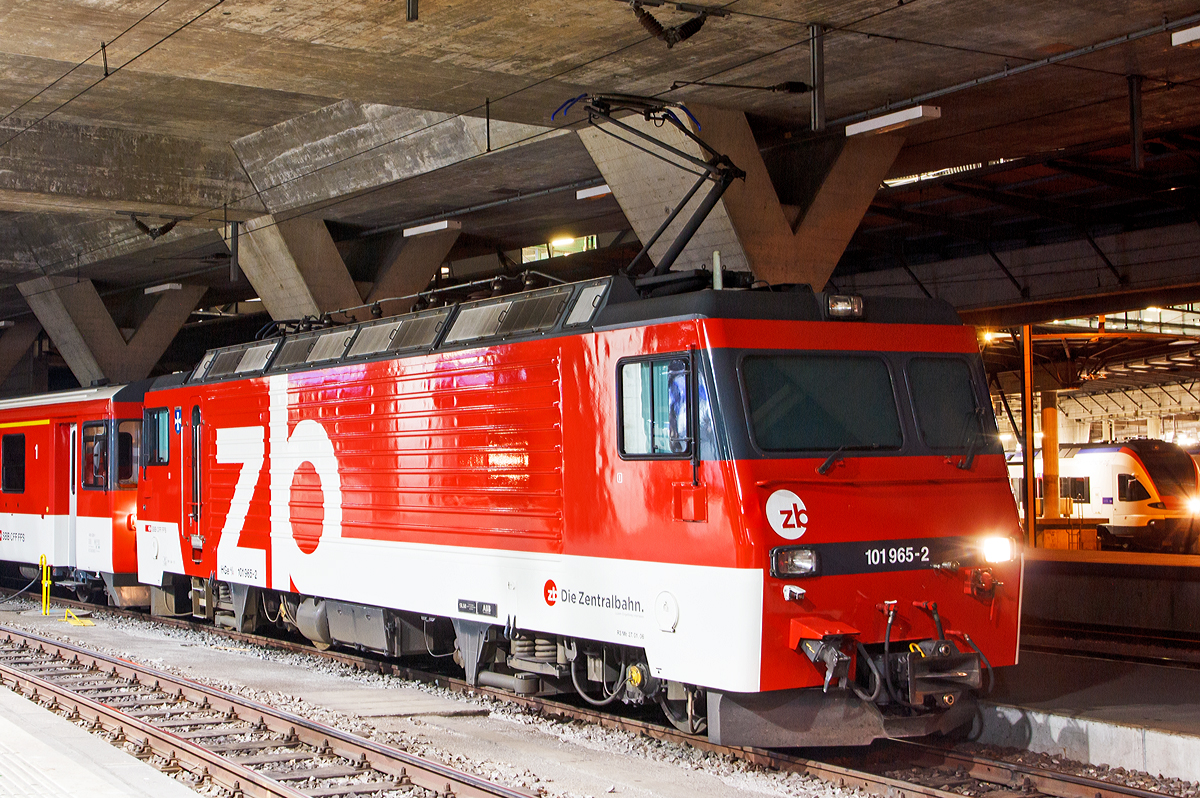 
Nachtschwärmereien - Die zb (Zentralbahn)  HGe 4/4 II - 101 965-2 „Lungern“  ist am 29.09.2012 (4:40 Uhr) mit einem Zug der zb im Bahnhof Luzern abgestellt. 

Die HGe 4/4 II 101 965-2 „Lungern“  wurde SLM (Schweizerische Lokomotiv- und Maschinenfabrik) in Winterthur 1990 unter der Fabriknummer 5399 gebaut, der elektrische Teil ist von ABB.

Die HGe 4/4 II - 101 ist eine schmalspurige (1.000 mm) gemischte Zahnrad- und Adhäsions-Lokomotive. Eine erste Serie von fünf Lokomotiven wurde gemeinsam von der Furka-Oberalp-Bahn (FO) sowie von der SBB für die Brünigbahn, die heute zur Zentralbahn (zb) gehört, beschafft. Da sich dieser Lokomotivtyp bewährte, wurden weitere elf Lokomotiven bestellt, und schließlich gab auch noch die Brig-Visp-Zermatt-Bahn (BVZ) fünf Loks in Auftrag.

Die HGe 4/4 II bespannt vor allem schwere Personenzüge, zum Teil im Pendelzugbetrieb. Bei der Zentralbahn bespannte sie bis 2012 alle Schnellzüge von Meiringen nach Luzern, bei der Matterhorn Gotthard Bahn die Züge des Glacier-Express. Weiter führen die Loks Pendelzüge Brig–Visp–Zermatt und seit der Eröffnung des Tunnels nach Engelberg Pendelzüge Luzern–Engelberg. Außerdem werden aushilfsweise Autopendelzüge durch den Furkatunnel geführt. Schließlich gehören neben weiteren Personenzügen auch diverse Güterzüge Visp–Zermatt sowie bis 2013 Disentis–Sedrun (NEAT-Baustelle) zum Aufgabengebiet.

Konstruktion:
Der Lokomotivkasten ist ein Stahlblechkasten mit gesickten Seitenwänden. Die asymmetrische Frontscheibe aus beheizbarem Verbundglas verbessert die Sicht für den Lokomotivführer. Die drei Dachelemente sind aus Aluminium. Die Pufferkräfte werden über Verstrebungen auf den ganzen Kasten übertragen, weshalb auf seitliche Maschinenraumöffnungen verzichtet werden musste. Der gesamte Kasten hat ein Gesamtgewicht von nur 5,9 Tonnen. Er kann ohne bleibende Deformation eine zentrale Druckkraft von 1000 kN aufnehmen.

Die Drehgestelle sind als geschweißte Hohlträgerkonstruktion mit zwei Längsträgern und einem kräftigen mittleren Querträger sowie zwei Kopftraversen ausgeführt. Sie haben einen Achsstand von 2980 mm, und die Flexicoilfedern stützen den Kasten auf die seitlich an die Längsträger angeschweißten Federwannen. Die Zug- und Druckkräfte werden durch seitlich angeordnete Stangen mit Sphärolastiklagern übertragen. Wegen des kurzen Achsstands sind die Fahrmotoren oberhalb des Drehgestellrahmens angebracht.

Für den Antrieb wurde erstmals der Differentialantrieb eingebaut, der es ermöglicht, im Zahnstangenbetrieb auch einen Anteil der Zugkraft über den Adhäsionsantrieb aufzubringen. Dies setzt wiederum eine Schlupfbegrenzung im Differentialgetriebe voraus, um ein Schleudern oder Gleiten der Räder zu verhindern. Da die zweilamellige Abtzahnstange (System Abt) der FO nicht die gesamte Zugkraft aufnehmen kann, ist die Mithilfe des Adhäsionsantriebs notwendig; dieser übernimmt einen Drittel der Zugkraft. Hätte sich der Antrieb nicht bewährt, wäre es zumindest am Brünig mit der Riggenbachzahnstange möglich gewesen, auf einen abkuppelbaren Adhäsionsantrieb zu wechseln. Dies war aber nicht notwendig, da das Differentialgetriebe zur vollen Zufriedenheit funktionierte.

Bremssysteme:
Dank der elektrischen Rekuperationsbremse ist eine gleichmäßige Beharrungsbremse bei der Talfahrt möglich.
Daneben ist eine normale automatische Druckluftbremse eingebaut, welche auch als Bremssystem I bezeichnet und im Regelbetrieb zum Halten des Zuges verwendet wird. Sie ist als Klotzbremse ausgeführt.
Weiterhin ist noch das Bremssystem II installiert, welches für Zahnradbahnen vorgeschrieben ist und es ermöglichen soll, den Zug nur mit Hilfe der Lokomotive im Zahnstangenabschnitt zum Halten zu bringen, wenn das erste Bremssystem ausfallen sollte. Dieses ist als federspeichergestütztes Bandbremssystem ausgelegt, welches direkt auf das Zahnrad wirkt. Bei Einsatz dieser Bremse treten enorme Kräfte auf, welche nur unter Kontrolle sind, wenn die Anhängelast bei der Talfahrt nicht zu groß ist.
Schließlich ist eine direkt wirkende Rangierbremse vorhanden, die sich der Bremsklötze des Bremssystems I bedient.
Die Lokomotive hat keine Handbremse, sondern wird mit Federspeicherbremsen gesichert.

Technische Daten, der HGe 4/4 II der zb (Brünigbahn), die der FO und BVZ weichen ab:
Spurweite: 1.000 mm
Achsformel: Bo'Bo'
Dienstgewicht: 63 t 
Achslast: 16 t
Länge über Puffer: 14'800 mm 
Höchstgeschwindigkeit Adhäsion: 100 km/h
Höchstgeschwindigkeit Zahnrad: 40 km/h
Stromsystem: 15 kV 16.7 Hz 
Anzahl der Motoren: 4
Antrieb: Gelenkwelle
Antrieb Zahnrad: Differentialantrieb
Zahnradsystem: 	Riggenbach 
Stundenleistung: 1.932 kW
Dauerleistung: 1.875 kW
Anfahrzugkraft: 230 kN (Adhäsion) / 280 kN (Zahnrad)
Anzahl Bremssysteme: 4
Bremsen: Rekuperation, Klotz, Federspeicher, Bandbremse
Anhängelast: 170 t (120 ‰) 

