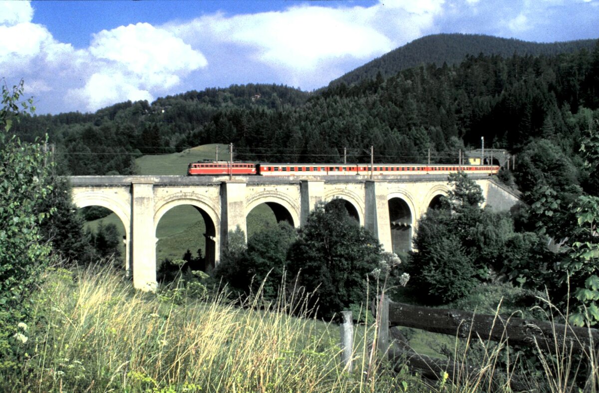 ÖBB 1042 mit Persnenzug am Semmering auf dem unteren Adlitzgraben-Viadukt am 09.08.1986.