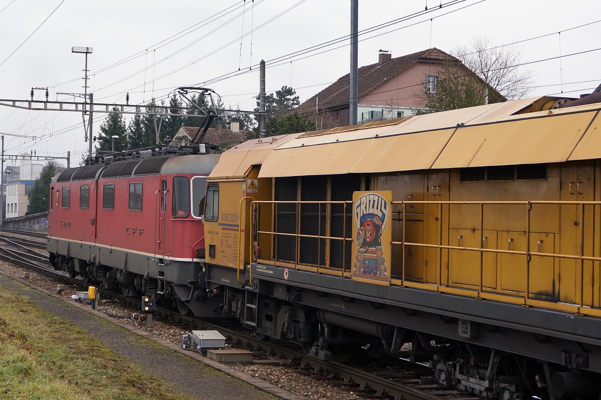 SBB: Güterzug mit der Re 6/6 11601  WOLHUSEN  beim Güterbahnhof Langenthal am 19. Januar 2015. Hier handelt es sich um einen Prototyp mit zweiteiligem Kasten. Von dieser Bauart existieren nur die 11601  WOLHUSEN  sowie die 11602  MORGES . In Langenthal wurde bei diesem Güterzug hinter der Re 6/6 eine Gleisbaumaschine von Scheuchzer eingereiht.  
Foto: Walter Ruetsch