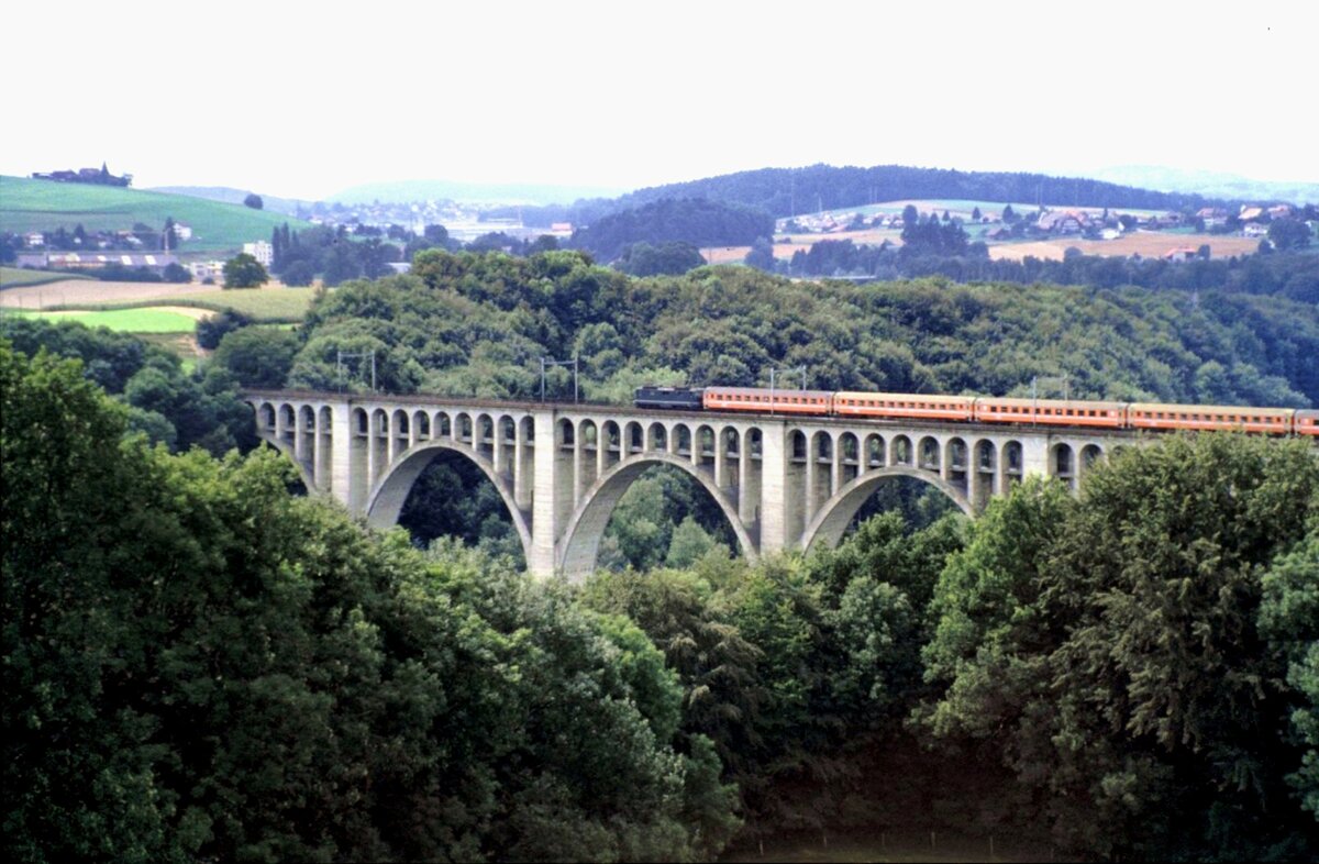 SBB Re 4/4 mit Eurocity-Zug auf dem Viadukt bei Fribourg am 25.08.1984.