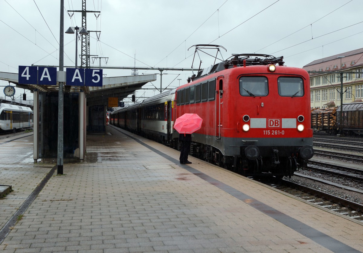 SBB/DB: Fotografieren in Singen am 20. November 2015 trotz starkem Wind und Dauerregen. Der IC Zrich - Stuttgart mit der 115 261-0 stand auf Gleis 5 zur Abfahrt bereit. Der Lokfhrer whrend der Entgegennahme der letzten Hinweise durch den Zugschef der Deutschen Bahn mit unpassendem Schirm.
Foto: Walter Ruetsch 