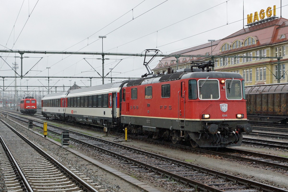 SBB/DB: Fotografieren in Singen am 20. November 2015 trotz starkem Wind und Dauerregen. Die 115 261-0 und die Re 4/4 mit zwei Bpm warteten gemeinsam auf dem selben Streckengeleise auf ihre nchsten Einstze. Da der IC aus Stuttgart nur aus drei 3 Bpm besteht, wurde dadurch die Weiterfahrt bis Zrich-HB um zwei Wagen verstrkt. 
Foto: Walter Ruetsch 