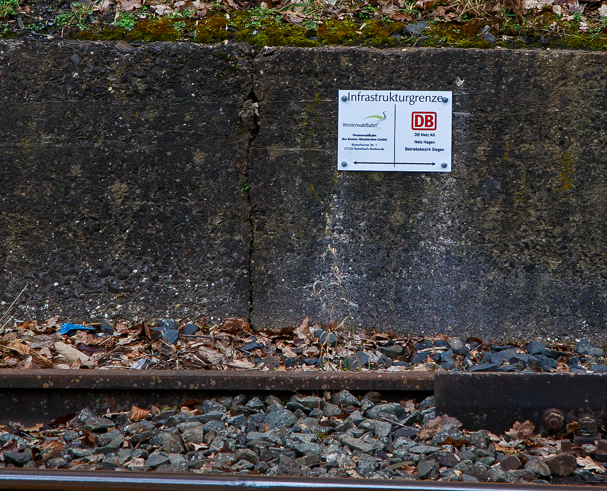 Schild/Tafel zur Kennzeichnung der Infrastrukturgrenze zwischen (links) der Westerwaldbahn des Kreises Altenkirchen GmbH (WEBA) mit Sitz in Steinebach-Bindweide und (rechts) der DB Netz AG, Netz Hagen, Betriebsbezirk Siegen. Die Anschlussgrenze bezieht sich aber nur auf das hintere von der Siegstrecke abzweigende Gleis.